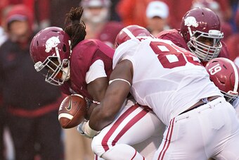 FAYETTEVILLE, AR - OCTOBER 11:  Alex Collins #3 of the Arkansas Razorbacks fumbles the ball while being tackled by A'Shawn Robinson #86 of the Alabama Crimson Tide at Razorback Stadium on October 11, 2014 in Fayetteville, Arkansas.  The Crimson Tide defea