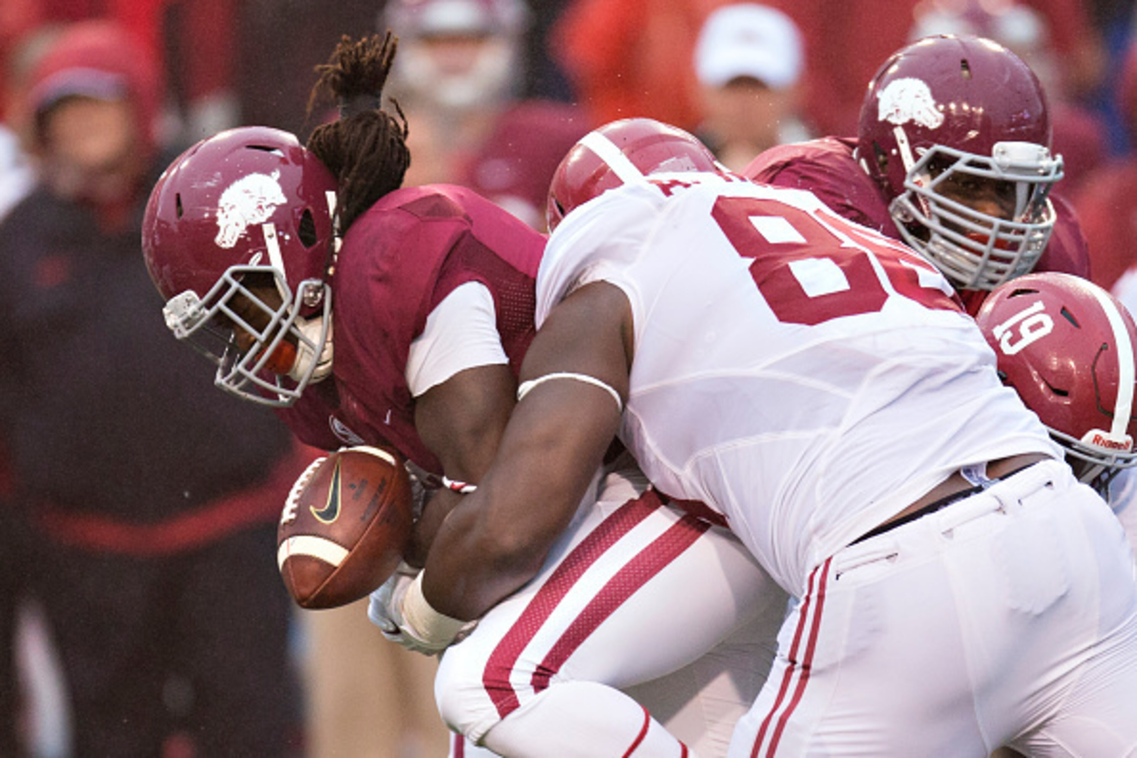 FAYETTEVILLE, AR - OCTOBER 11:  Alex Collins #3 of the Arkansas Razorbacks fumbles the ball while being tackled by A'Shawn Robinson #86 of the Alabama Crimson Tide at Razorback Stadium on October 11, 2014 in Fayetteville, Arkansas.  The Crimson Tide defea