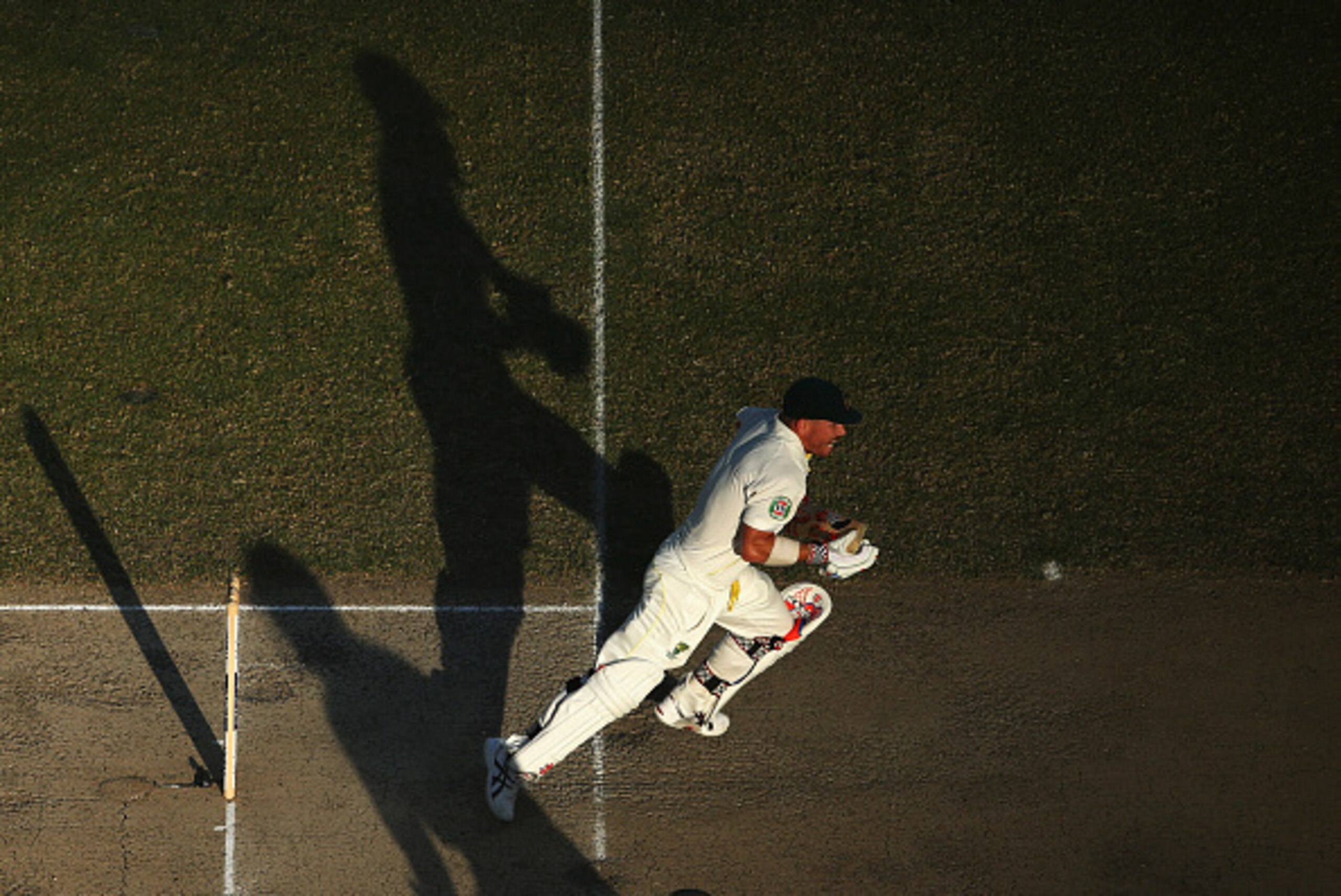 DUBAI, UNITED ARAB EMIRATES - OCTOBER 23:  David Warner of Australia sets off for a run during Day Two of the First Test between Pakistan and Australia at Dubai International Stadium on October 23, 2014 in Dubai, United Arab Emirates.  (Photo by Ryan Pier