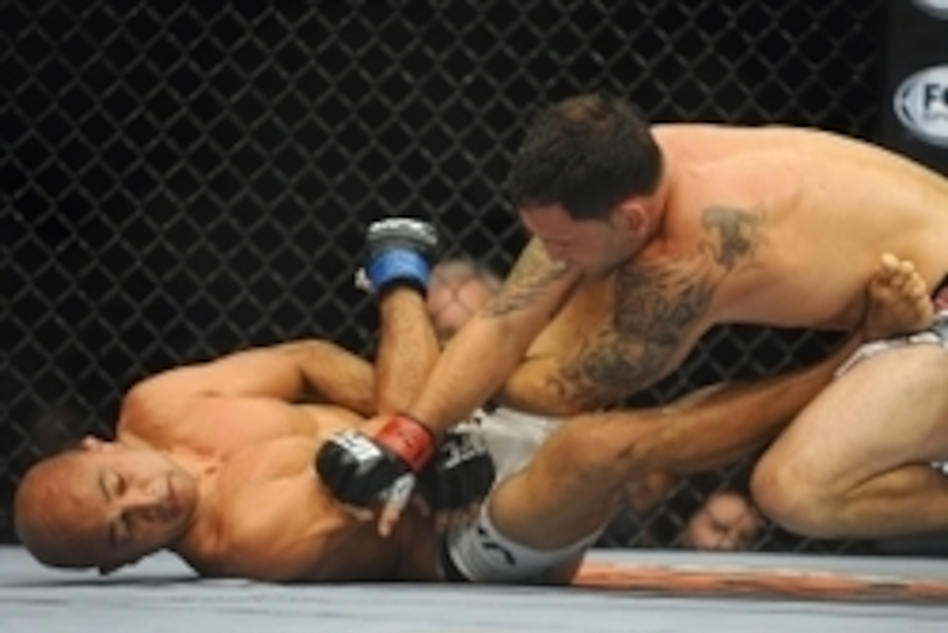 Jul 6, 2014; Las Vegas, NV, USA; Frankie Edgar (red gloves) throws punches at a prone B.J. Penn (blue gloves) during their featherweight bout at Mandalay Bay Events Center. Mandatory Credit: Stephen R. Sylvanie-USA TODAY Sports