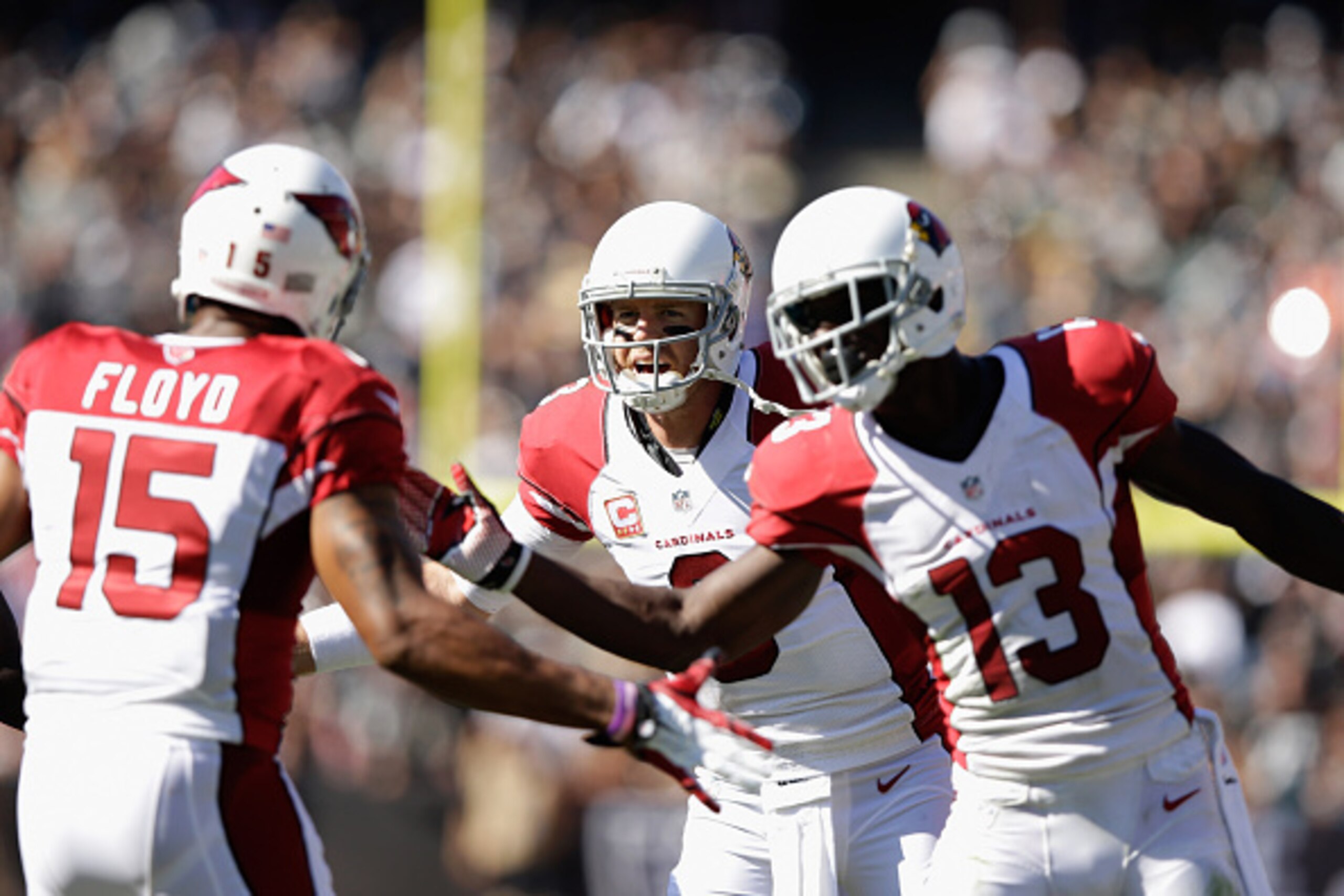 OAKLAND, CA - OCTOBER 19: Carson Palmer #3 of the Arizona Cardinals celebrates a touchdown with teammates Jaron Brown #13 of the Arizona Cardinals and Michael Floyd #15 of the Arizona Cardinals in the first half against the Oakland Raiders at O.co Coliseu