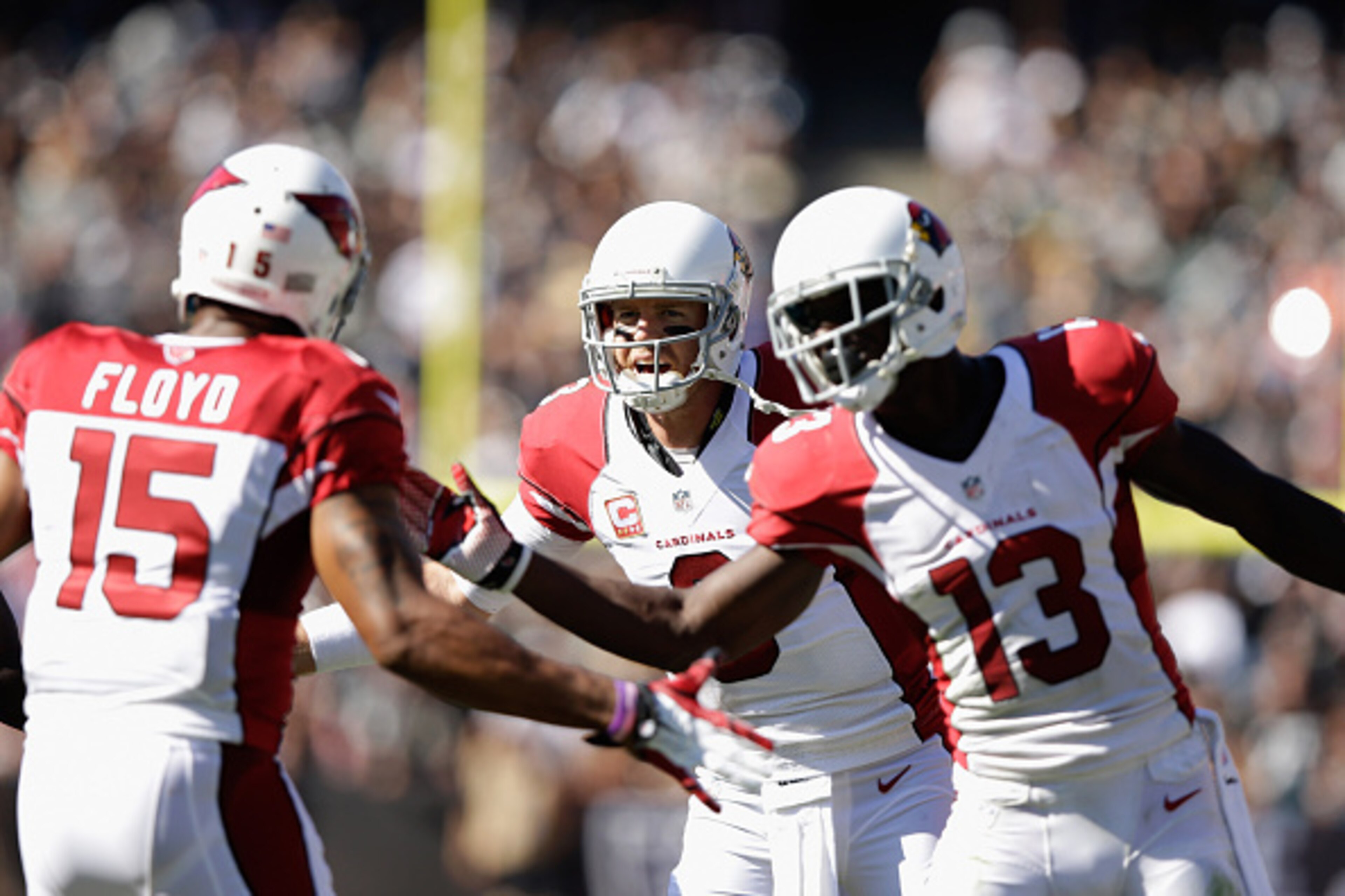 OAKLAND, CA - OCTOBER 19: Carson Palmer #3 of the Arizona Cardinals celebrates a touchdown with teammates Jaron Brown #13 of the Arizona Cardinals and Michael Floyd #15 of the Arizona Cardinals in the first half against the Oakland Raiders at O.co Coliseu