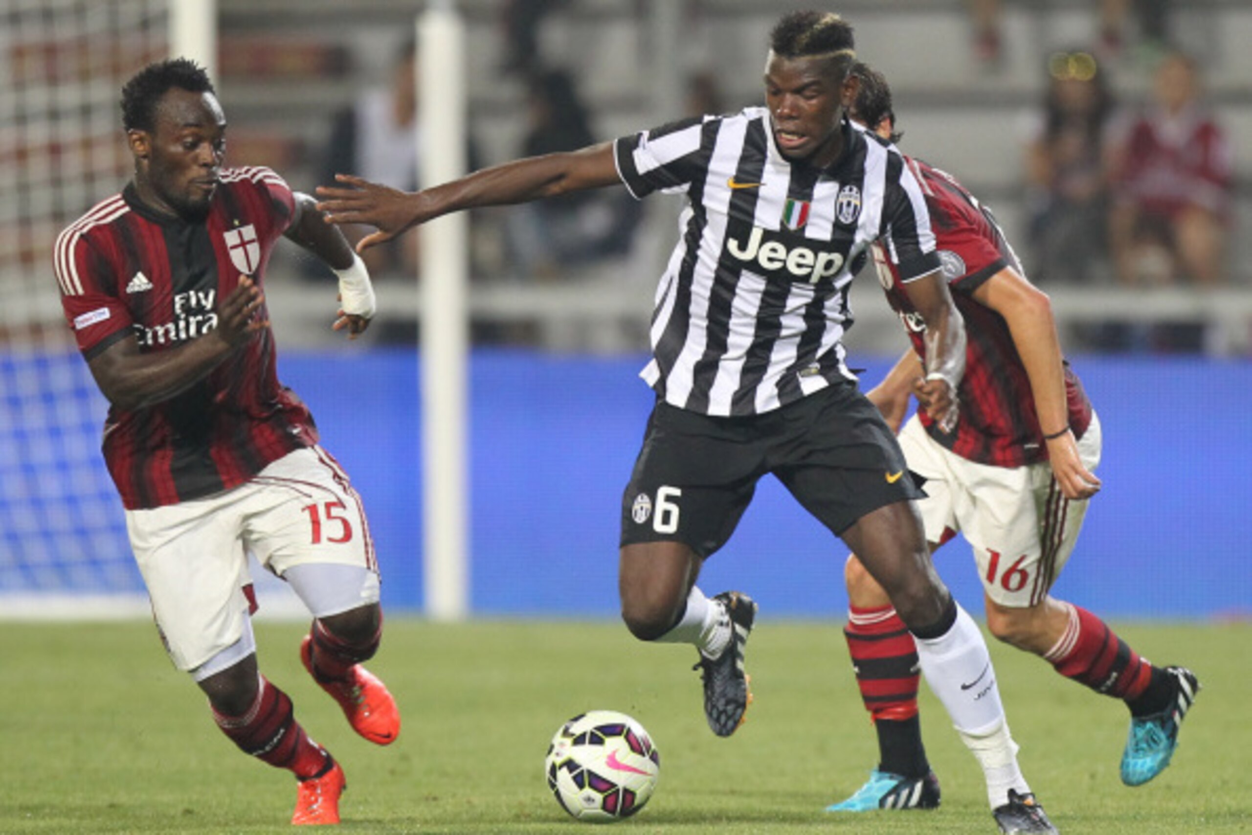 REGGIO NELL'EMILIA, ITALY - AUGUST 23: Paul Pogba (C) of FC Juventus competes for the ball with Michael Essien of AC Milan during the TIM Preseason Tournament between US Sassuolo, FC Juventus and AC Milan at Mapei Stadium - Citta' del Tricolore on August 