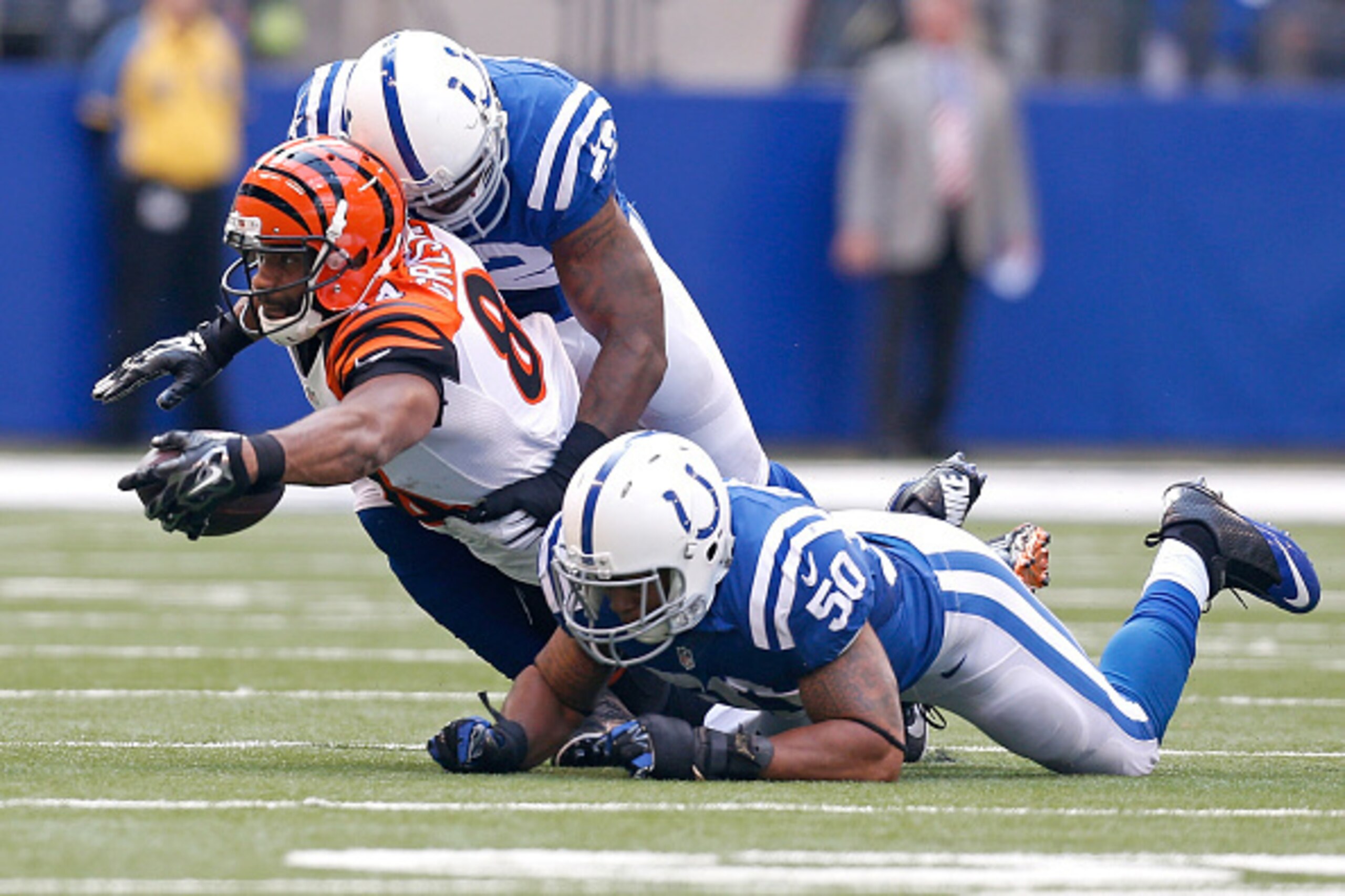 INDIANAPOLIS, IN - OCTOBER 19:  Jermaine Gresham #84 of the Cincinnati Bengals reaches for extra yards while being tackled by D'Qwell Jackson #52 of the Indianapolis Colts and Jerrell Freeman #50 of the Indianapolis Colts during the second quarter on Octo