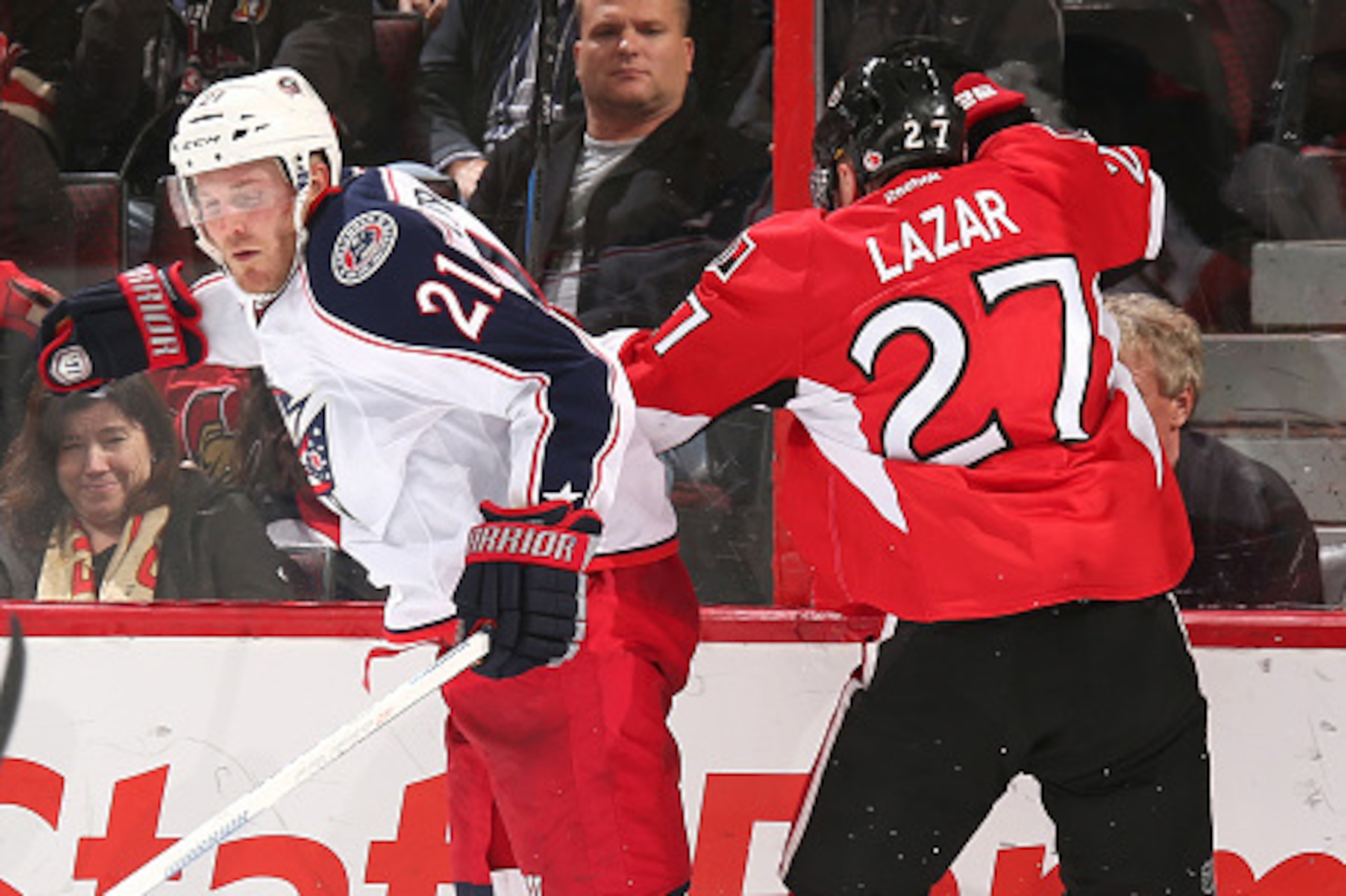 OTTAWA, ON - OCTOBER 18: Curtis Lazar #27 of the Ottawa Senators collides with James Wisniewski #21 of the Columbus Blue Jackets along the boards at Canadian Tire Centre on October 18, 2014 in Ottawa, Ontario, Canada.  (Photo by Andre Ringuette/NHLI via G