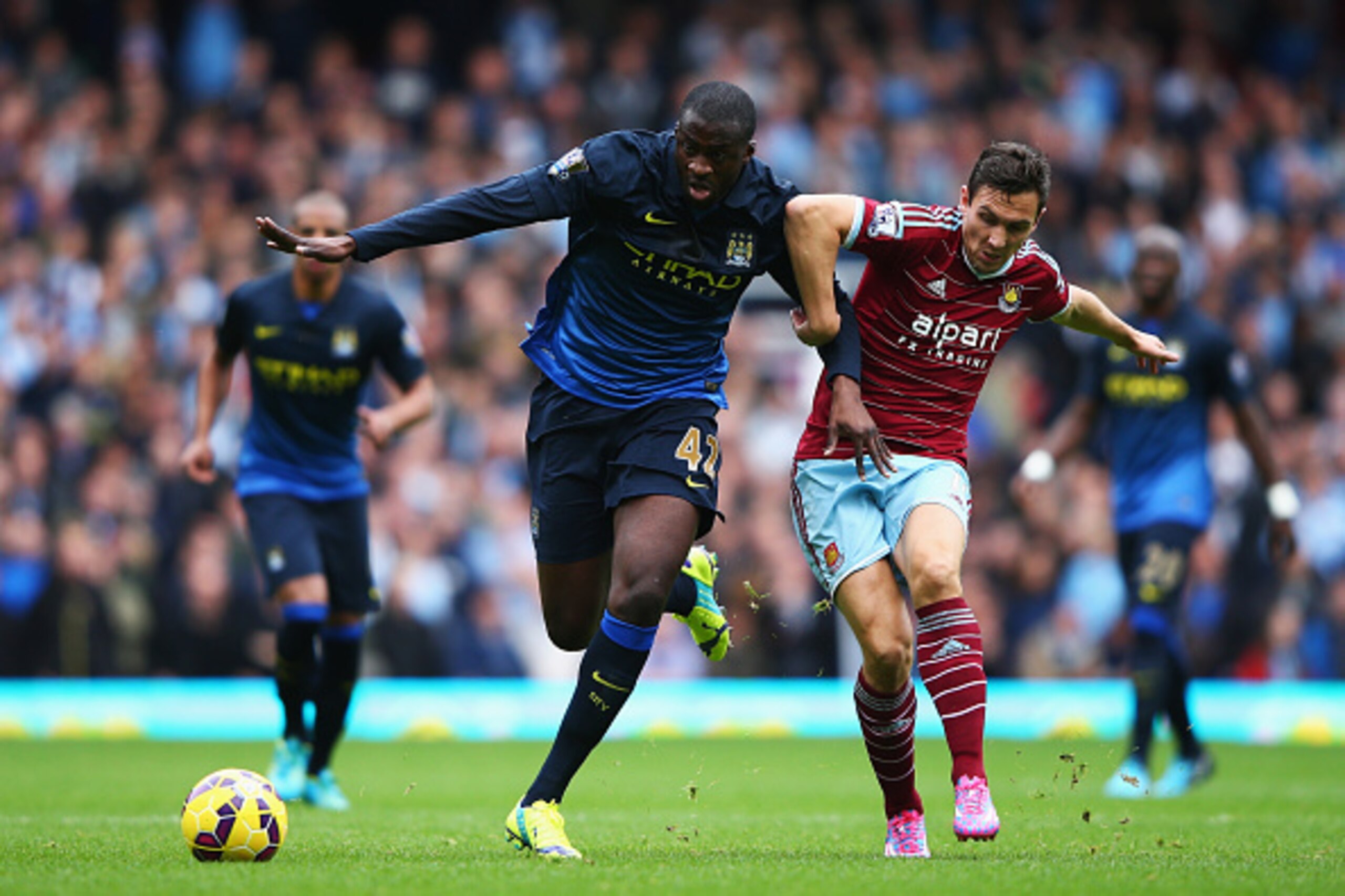 LONDON, ENGLAND - OCTOBER 25:  Yaya Toure of Manchester City is tackled by Stewart Downing of West Ham United during the Barclays Premier League match between West Ham United and Manchester City at Boleyn Ground on October 25, 2014 in London, England.  (P