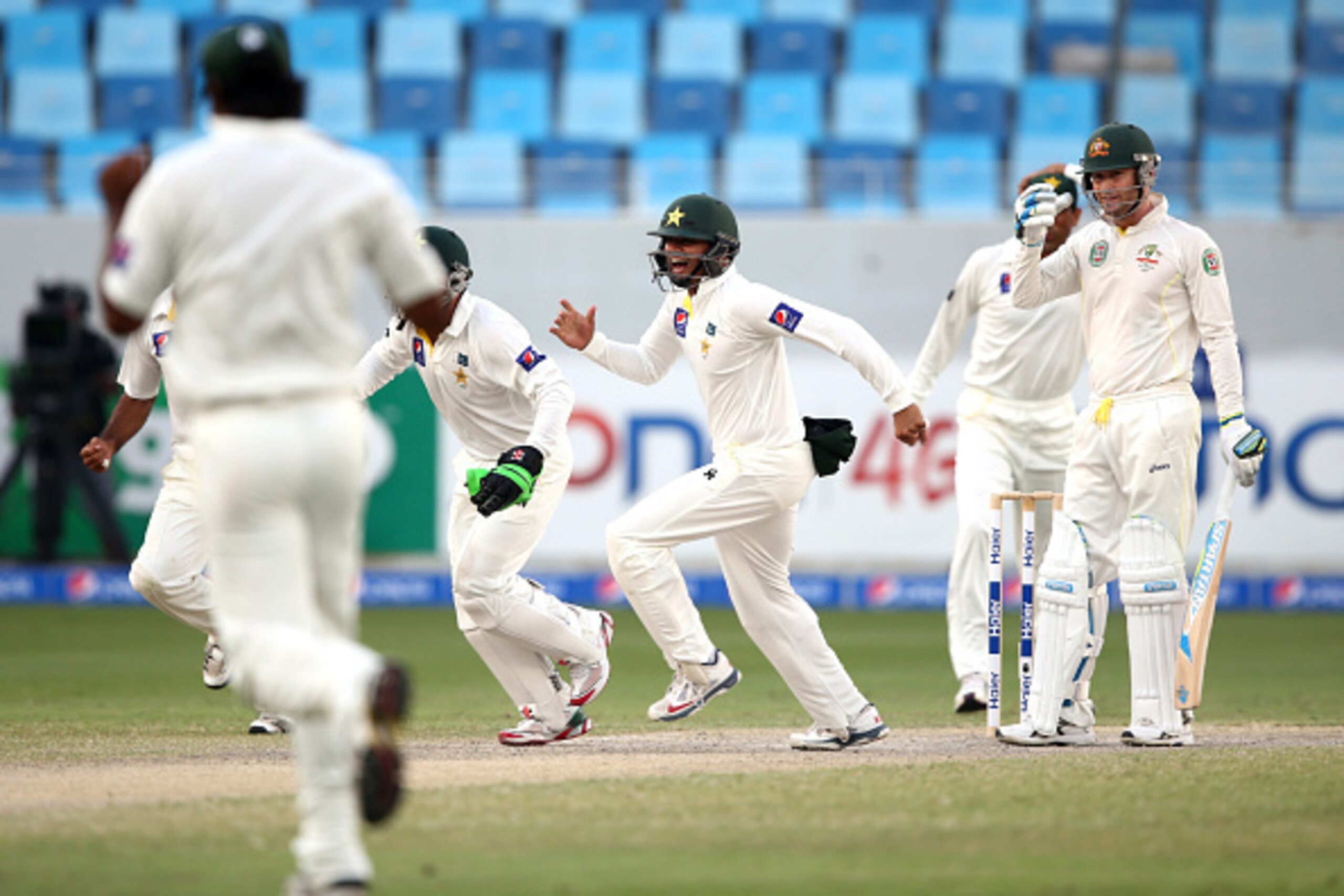 DUBAI, UNITED ARAB EMIRATES - OCTOBER 25:  The Pakistan players celebrate as Australian Captain, Michael Clarke is dismissed lbw by Yasir Shah during day four of the First Test between Pakistan and Australia at Dubai International Stadium at Dubai Interna