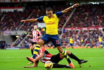 SUNDERLAND, ENGLAND - OCTOBER 25:  Alex Oxlade-Chamberlain of Arsenal holds off the challenge from Lee Cattermole of Sunderland during the Barclays Premier League match between Sunderland and Arsenal at the Stadium of Light on October 25, 2014 in Sunderla