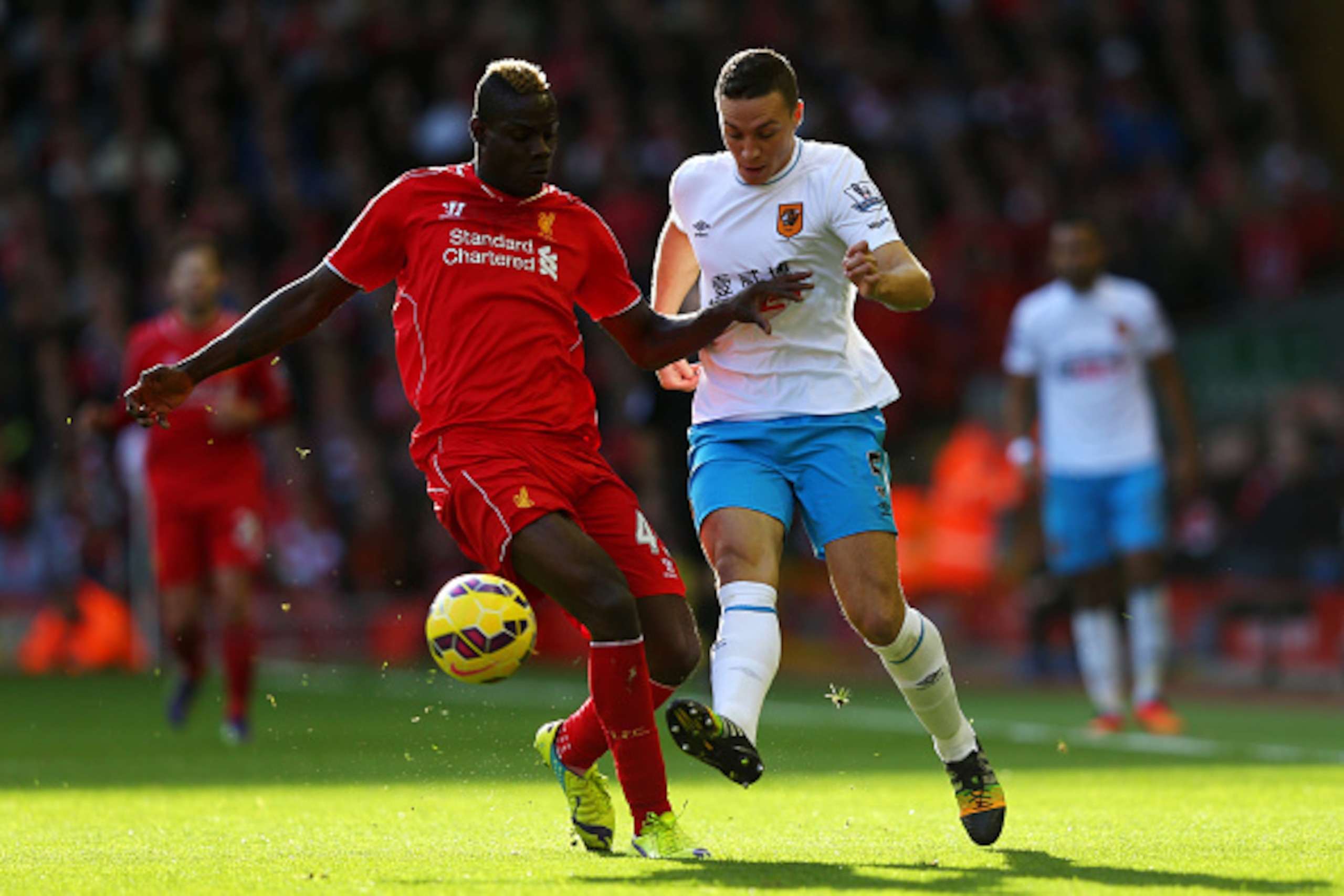 LIVERPOOL, ENGLAND - OCTOBER 25:  Mario Balotelli of Liverpool is challenged by James Chester of Hull City during the Barclays Premier League match between Liverpool and Hull City at Anfield on October 25, 2014 in Liverpool, England.  (Photo by Alex Lives