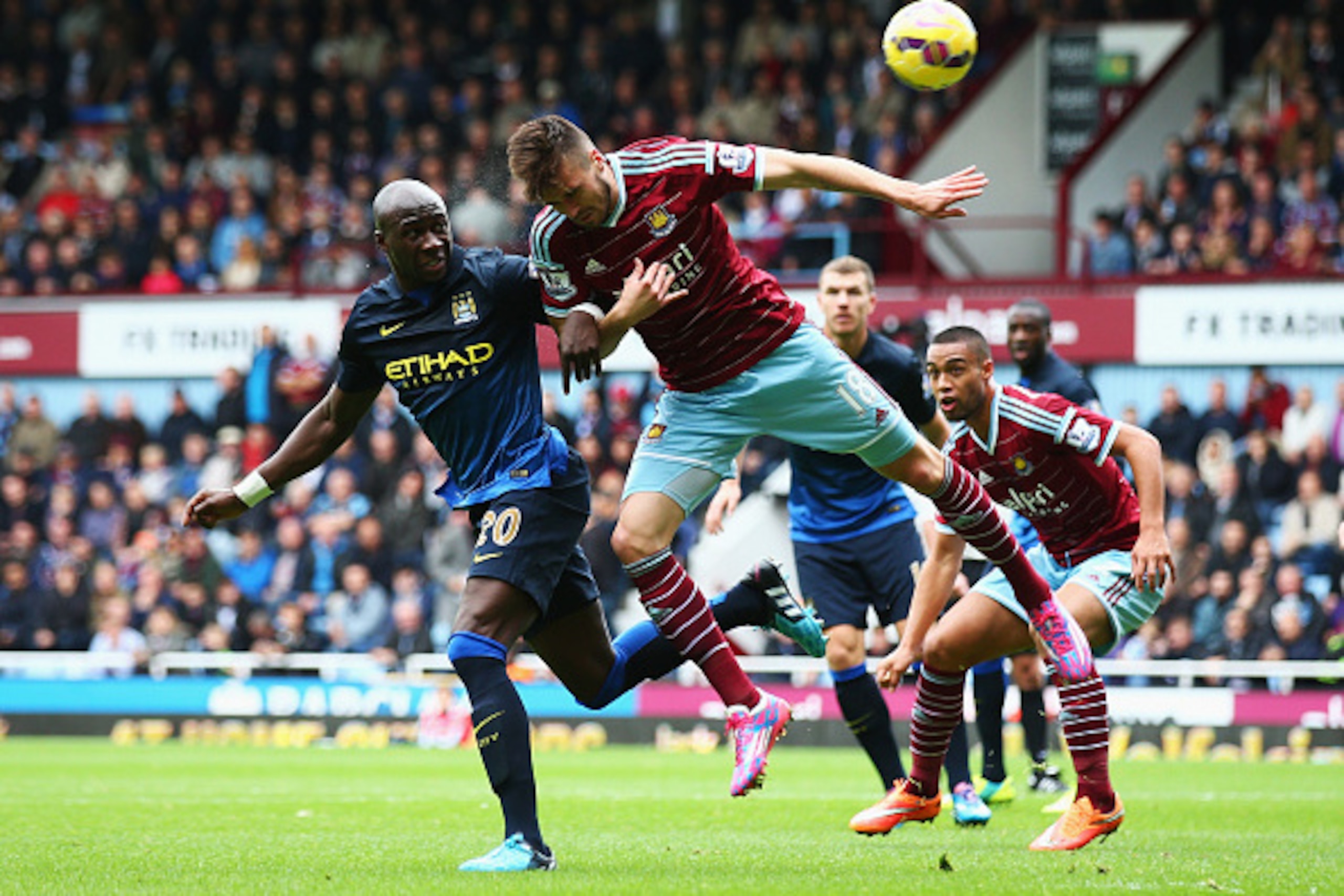 LONDON, ENGLAND - OCTOBER 25: Eliaquim Mangala of Manchester City challenges for a header with Carl Jenkinson of West Ham United during the Barclays Premier League match between West Ham United and Manchester City at Boleyn Ground on October 25, 2014 in L