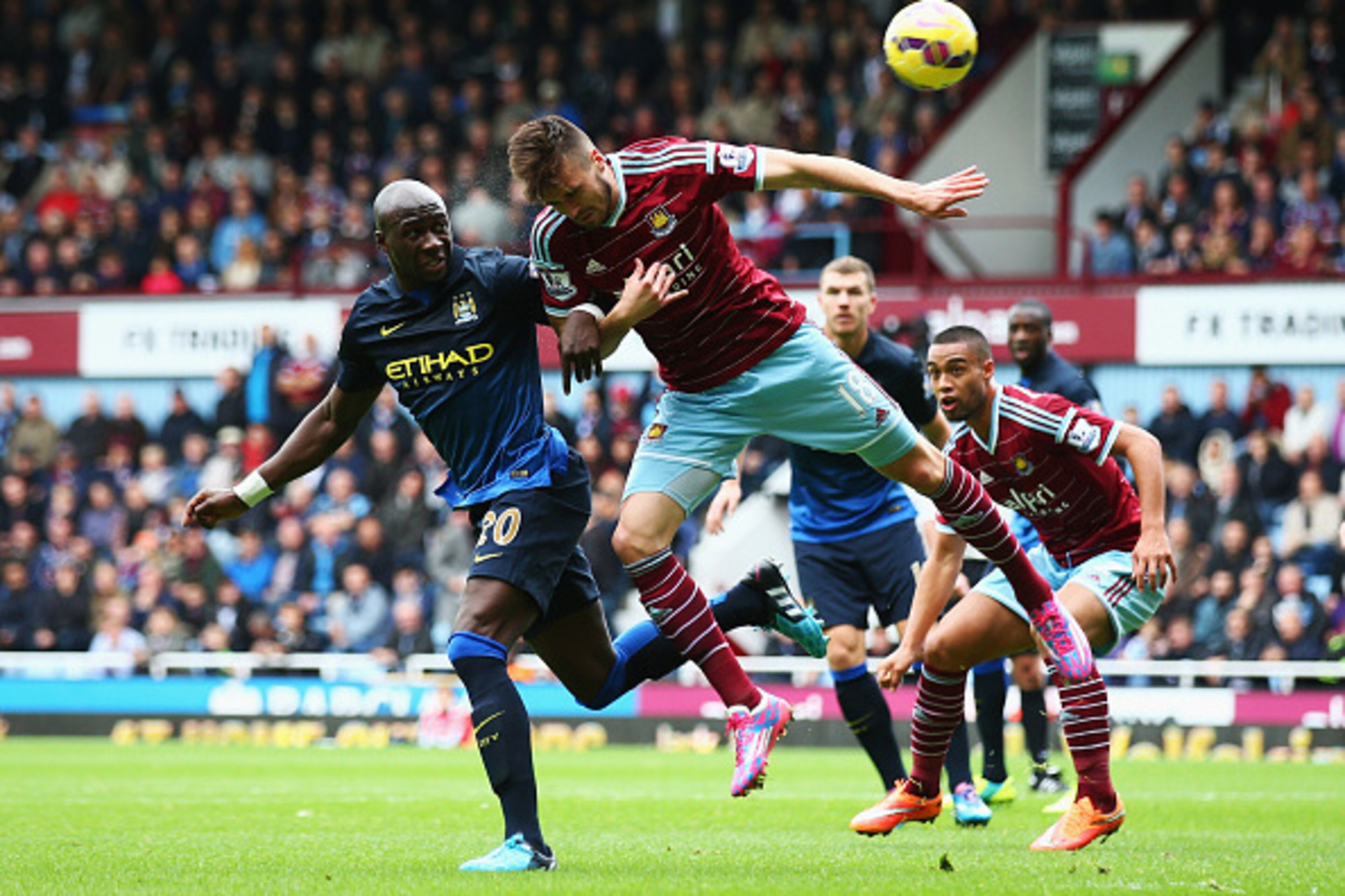 LONDON, ENGLAND - OCTOBER 25: Eliaquim Mangala of Manchester City challenges for a header with Carl Jenkinson of West Ham United during the Barclays Premier League match between West Ham United and Manchester City at Boleyn Ground on October 25, 2014 in L