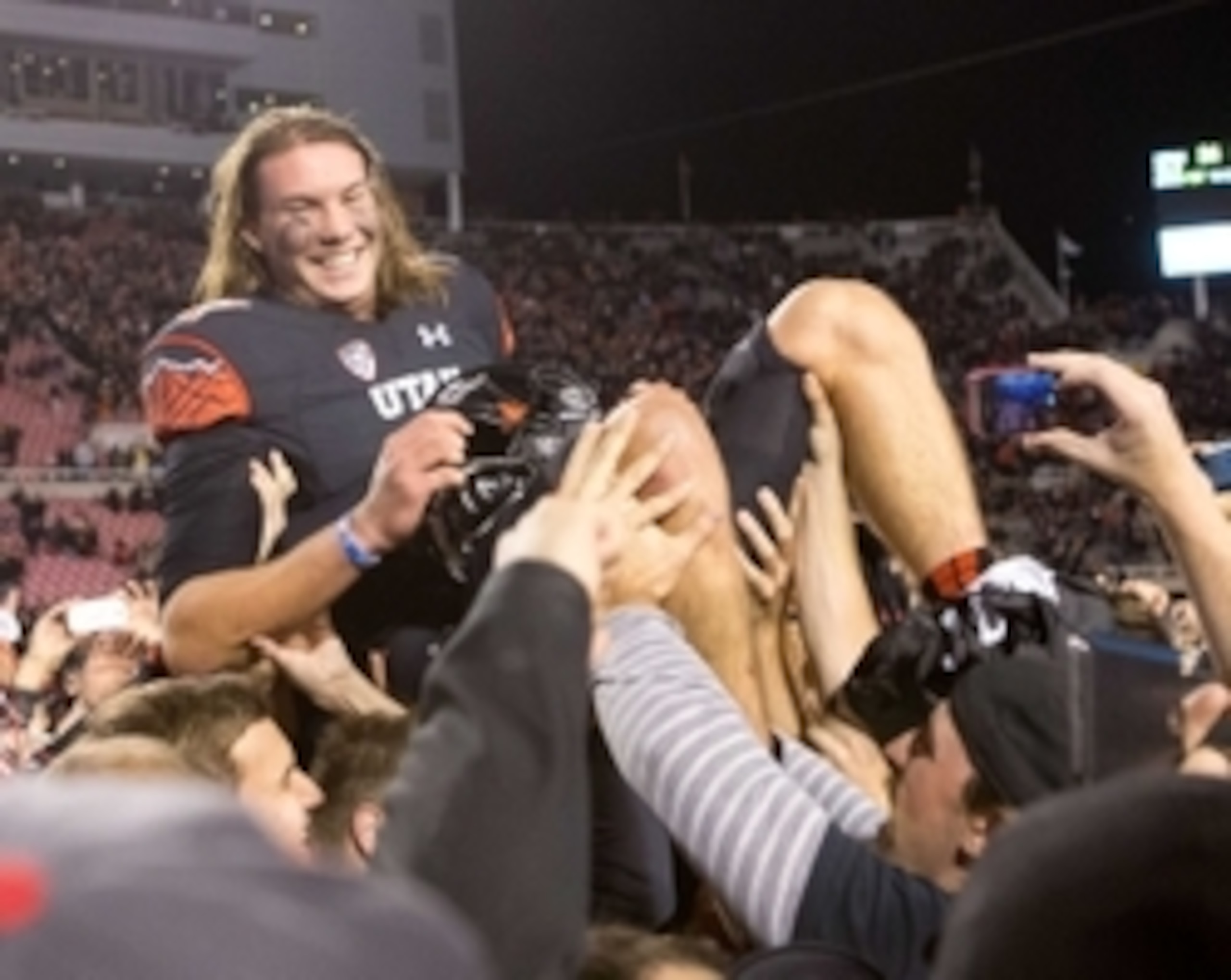 Oct 25, 2014; Salt Lake City, UT, USA; Utah Utes quarterback Travis Wilson (7) is lifted onto the shoulders of teammates and fans after Utah defeated the USC Trojans 24-21 at Rice-Eccles Stadium. Mandatory Credit: Russ Isabella-USA TODAY Sports