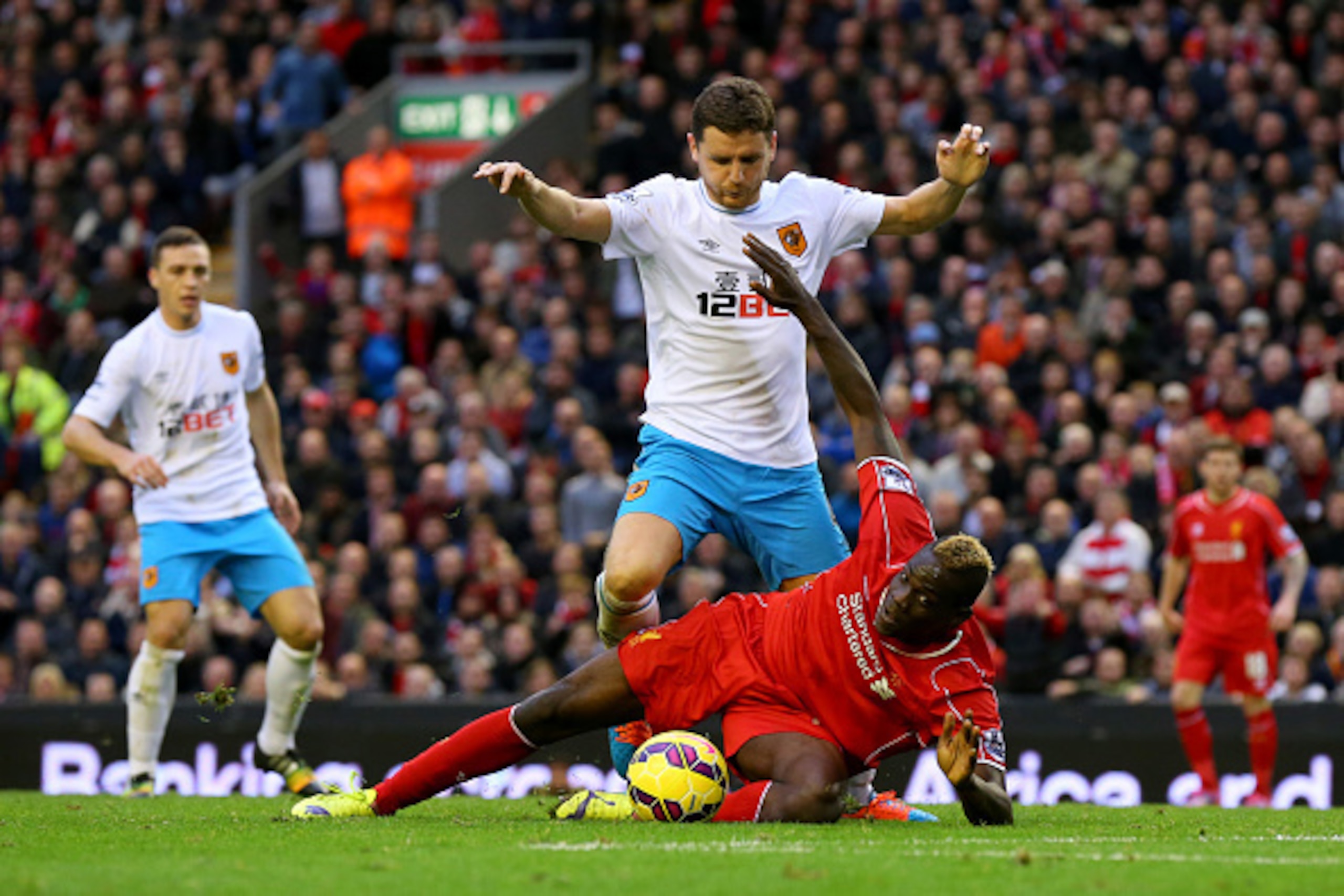 LIVERPOOL, ENGLAND - OCTOBER 25:  Mario Balotelli of Liverpool battles for the ball with Alex Bruce of Hull City during the Barclays Premier League match between Liverpool and Hull City at Anfield on October 25, 2014 in Liverpool, England.  (Photo by Alex