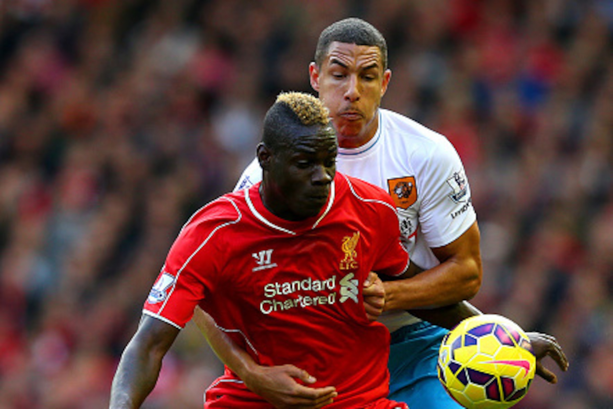 LIVERPOOL, ENGLAND - OCTOBER 25:  Mario Balotelli of Liverpool battles for the ball with Curtis Davies of Hull City during the Barclays Premier League match between Liverpool and Hull City at Anfield on October 25, 2014 in Liverpool, England.  (Photo by A