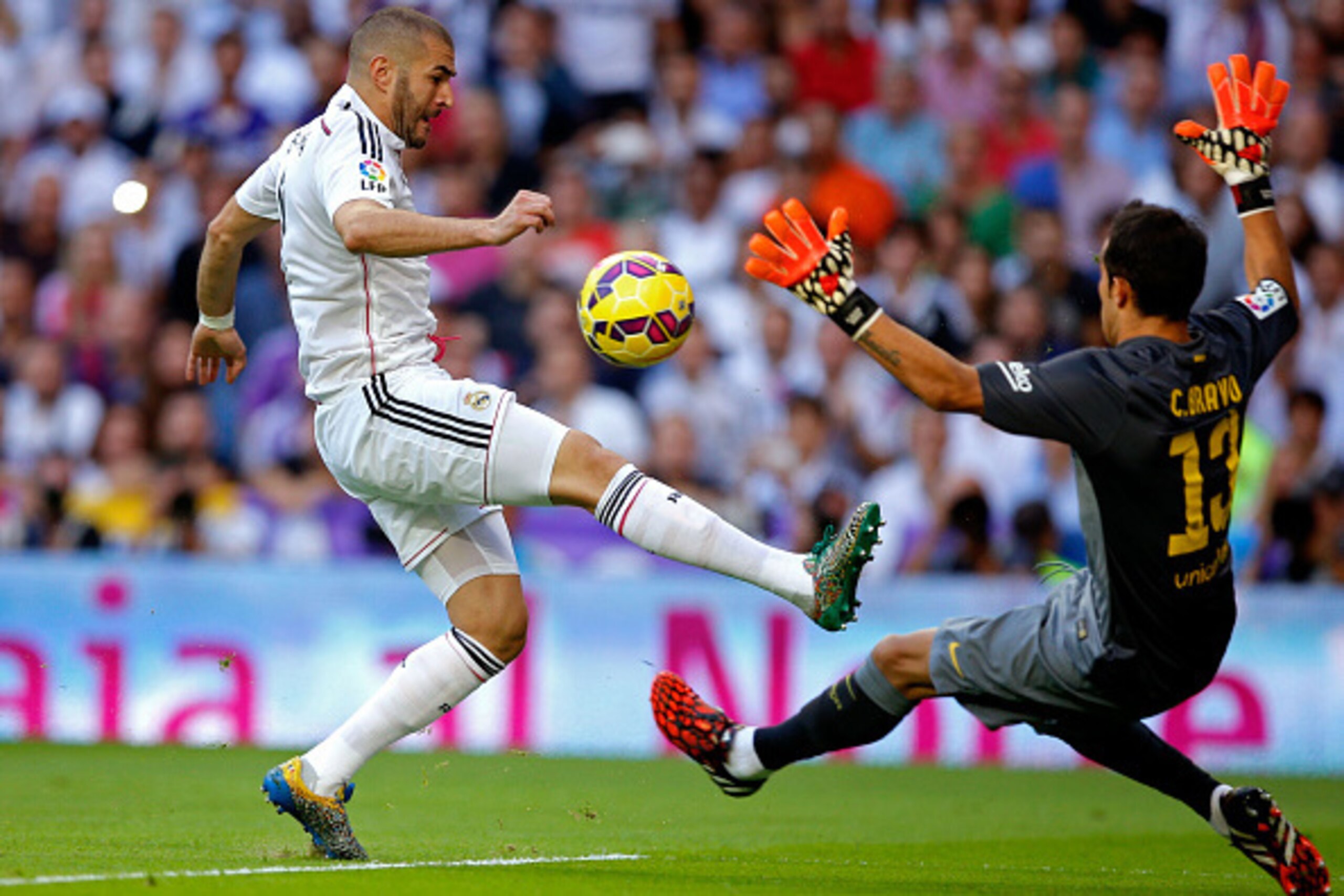 MADRID, SPAIN - OCTOBER 25:  Karim Benzema of Real Madrid CF attempts to lift the ball over Claudio Bravo of FC Barcelona during the La Liga match between Real Madrid CF and FC Barcelona at Estadio Santiago Bernabeu on October 25, 2014 in Madrid, Spain.  
