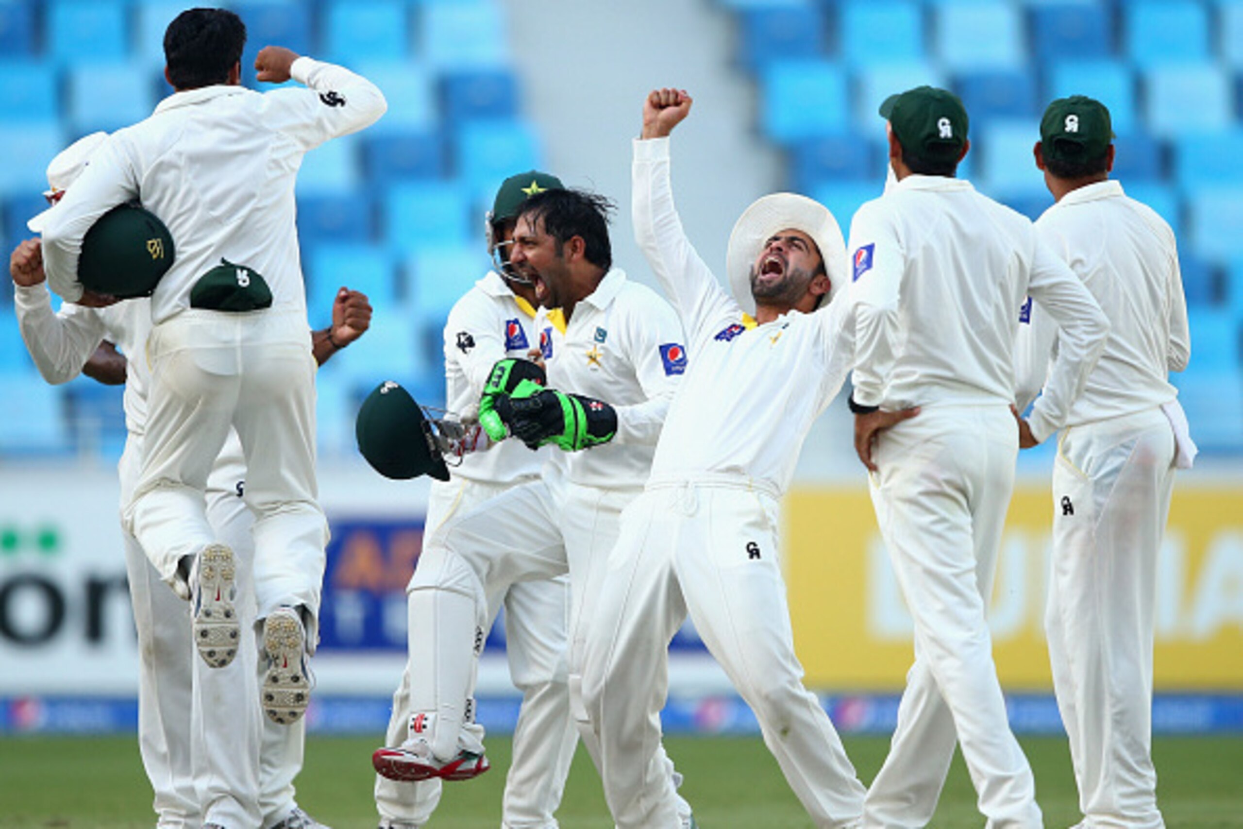 DUBAI, UNITED ARAB EMIRATES - OCTOBER 26:  Ahmed Shehzad of Pakistan celebrates after Yasir Shah oand Sarfraz Ahmed of Pakistan claimed the wicket of Mohammad Talha of Pakistan during Day Five of the First Test between Pakistan and Australia at Dubai Inte