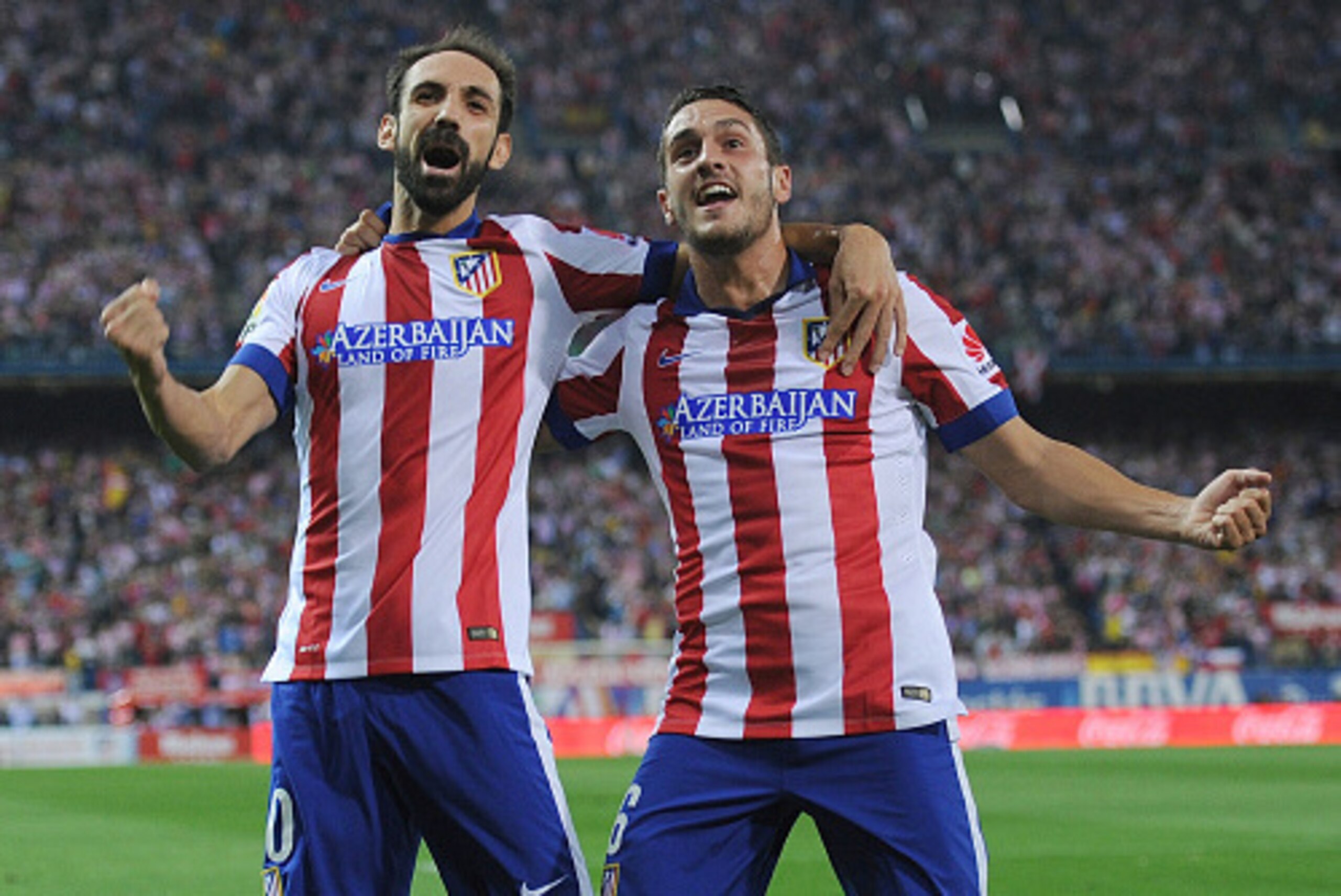 MADRID, SPAIN - SEPTEMBER 27:  Koke (R) of Club Atletico de Madrid celebrates with Juanfran after scoring his team's opening goal during the La Liga match between Club Atletico de Madrid and Sevilla FC at Vicente Calderon Stadium on September 27, 2014 in 