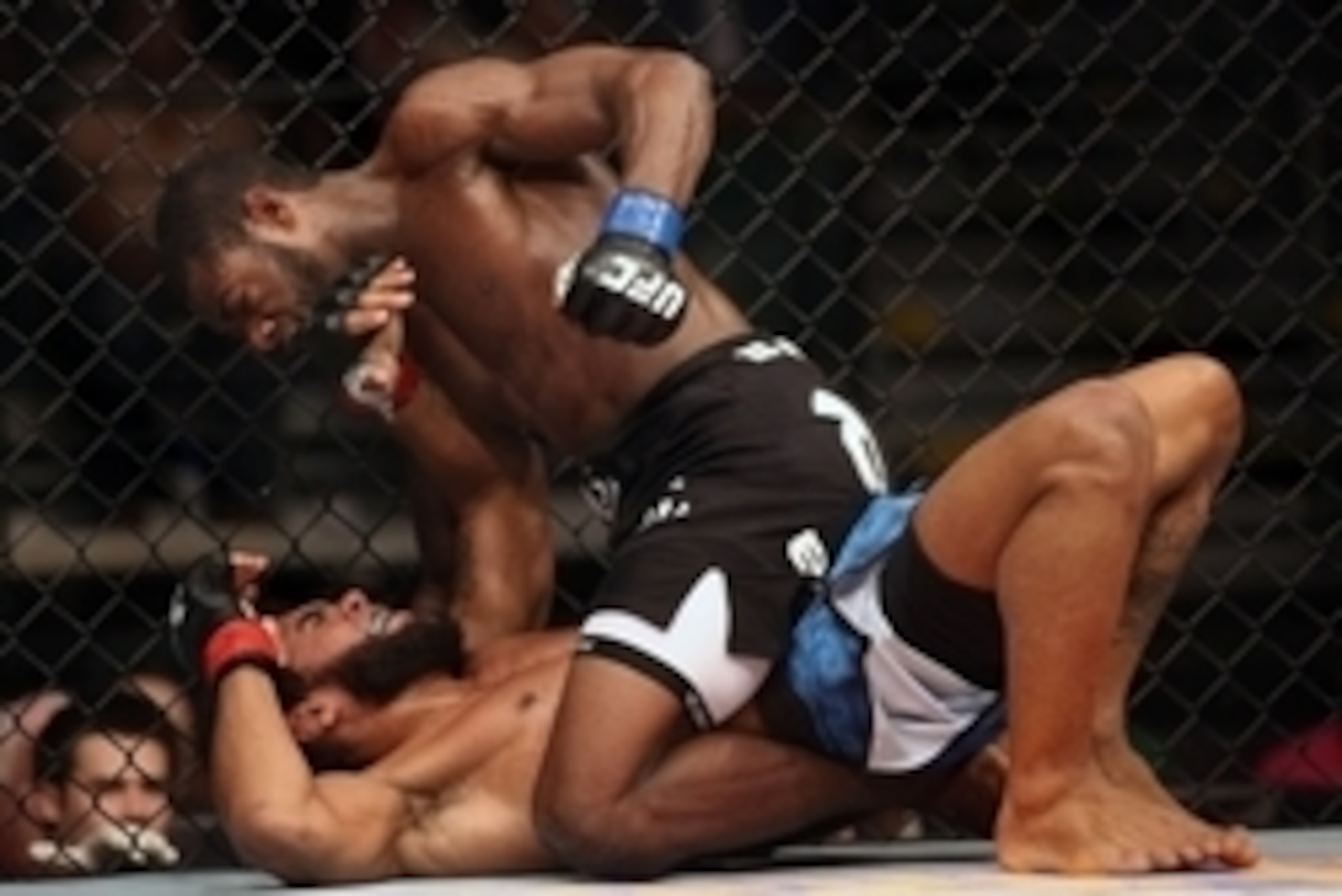 Jul 16, 2014; Atlantic City, NJ, USA; Aljamain Sterling pulls back for a punch while on top of a prone Hugo Viana (red gloves) during a bantamweight bout at Revel Casino. Mandatory Credit: Bill Streicher-USA TODAY Sports