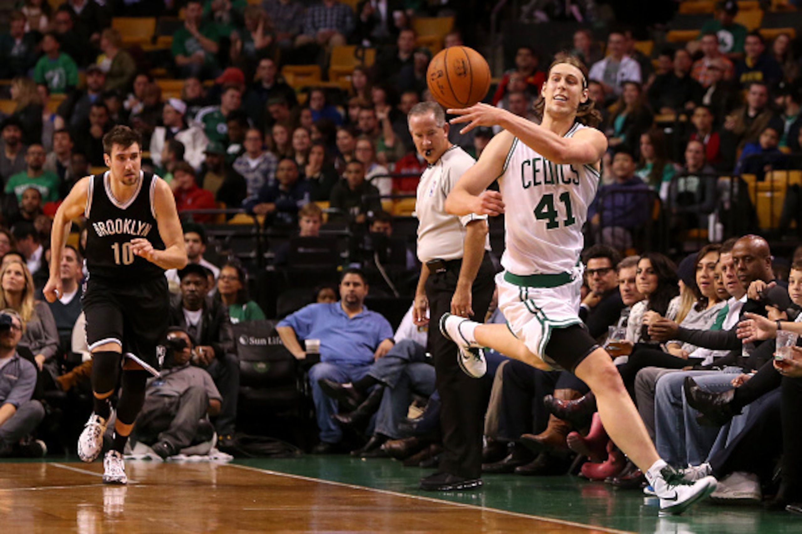 BOSTON, MA - OCTOBER 22:  Kelly Olynyk #41 of the Boston Celtics jumps to save the ball from going out of bounds against the Brooklyn Nets during a preseason game at TD Garden on October 22, 2014 in Boston, Massachusetts. NOTE TO USER: User expressly ackn