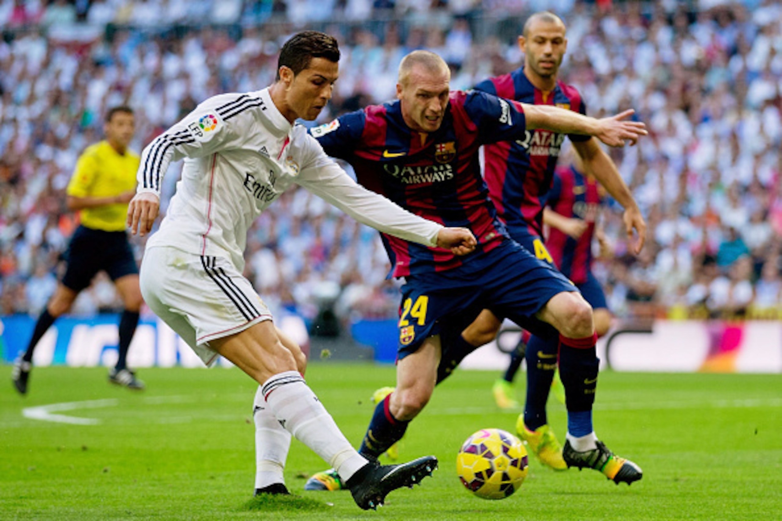 MADRID, SPAIN - OCTOBER 25: Cristiano Ronaldo of Real Madrid CF looks to cross the ball under pressure from Jeremy Mathieu of Barcelona during the La Liga match between Real Madrid CF and FC Barcelona at Estadio Santiago Bernabeu on October 25, 2014 in M MADRID, SPAIN - OCTOBER 25: Cristiano Ronaldo of Real Madrid CF looks to cross the ball under pressure from Jeremy Mathieu of Barcelona during the La Liga match between Real Madrid CF and FC Barcelona at Estadio Santiago Bernabeu on October 25, 2014 in M