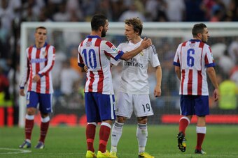 MADRID, SPAIN - SEPTEMBER 13:  Arda Turan of Club Atletico de Madrid chats with Luka Modric of Real Madrid at the end of the La Liga match between Real Madrid and Atletico de Madrid at Estadio Santiago Bernabeu on September 13, 2014 in Madrid, Spain. Atle