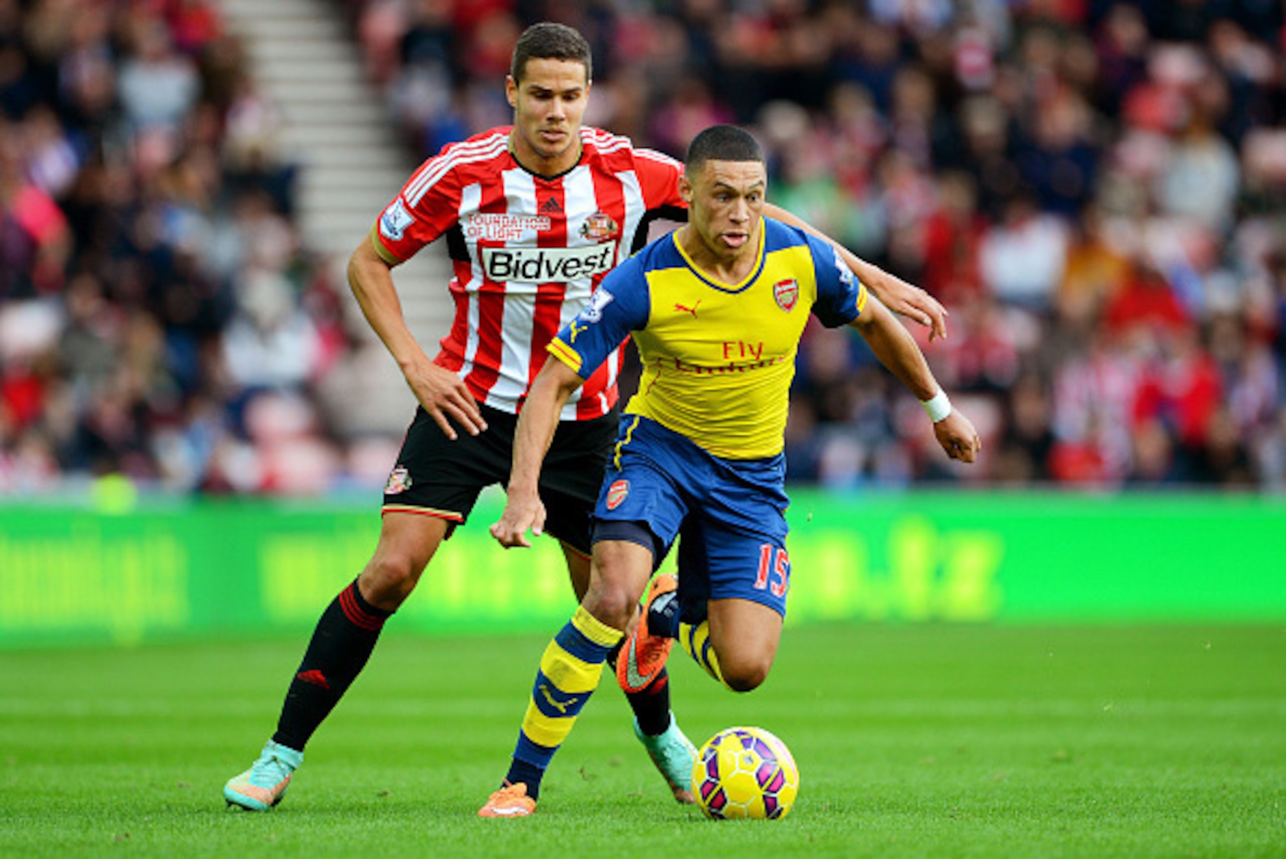 SUNDERLAND, ENGLAND - OCTOBER 25:  Alex Oxlade-Chamberlain of Arsenal is pursued by Jack Rodwell of Sunderland during the Barclays Premier League match between Sunderland and Arsenal at the Stadium of Light on October 25, 2014 in Sunderland, England.  (Ph