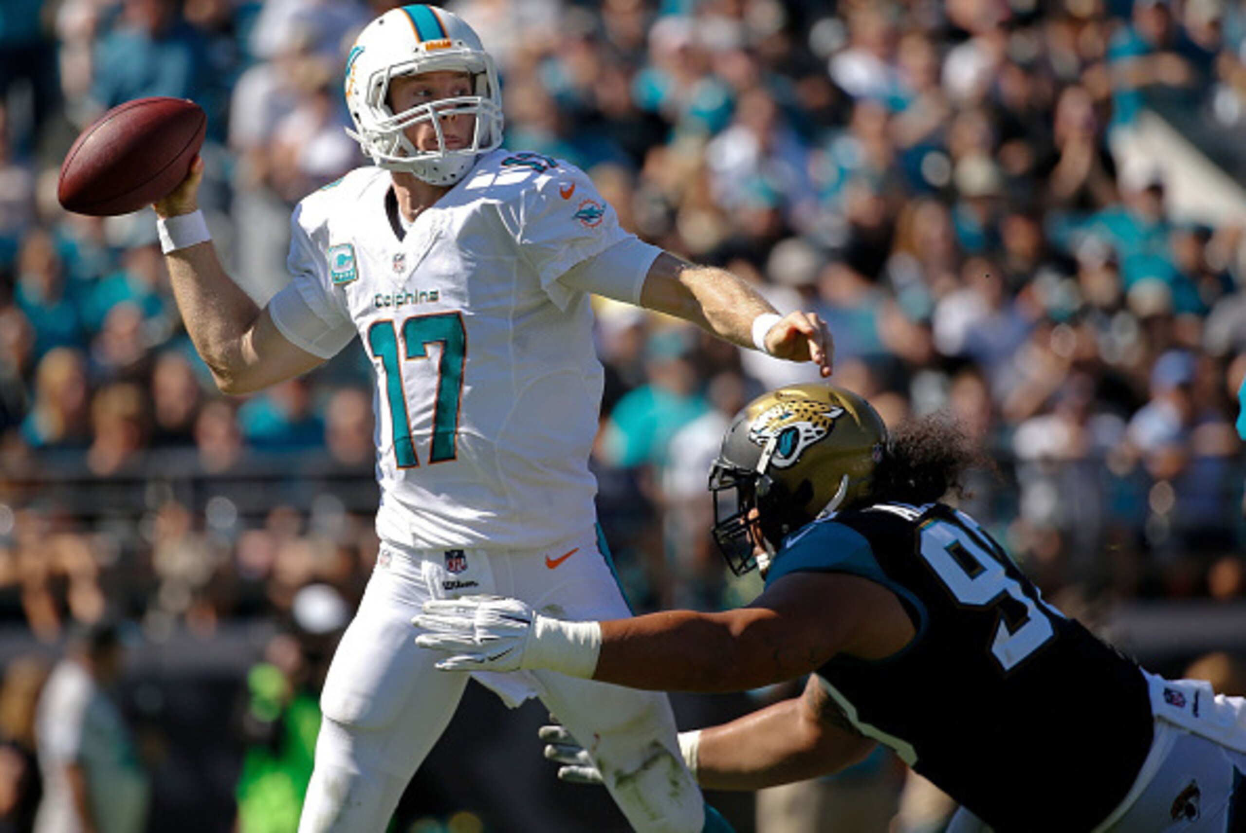 JACKSONVILLE, FL - OCTOBER 26: Ryan Tannehill #17 of the Miami Dolphins is pressued by Tyson Alualu #93 of the Jacksonville Jaguars during the second quarter of the game at EverBank Field on October 26, 2014 in Jacksonville, Florida.  (Photo by Rob Foldy/