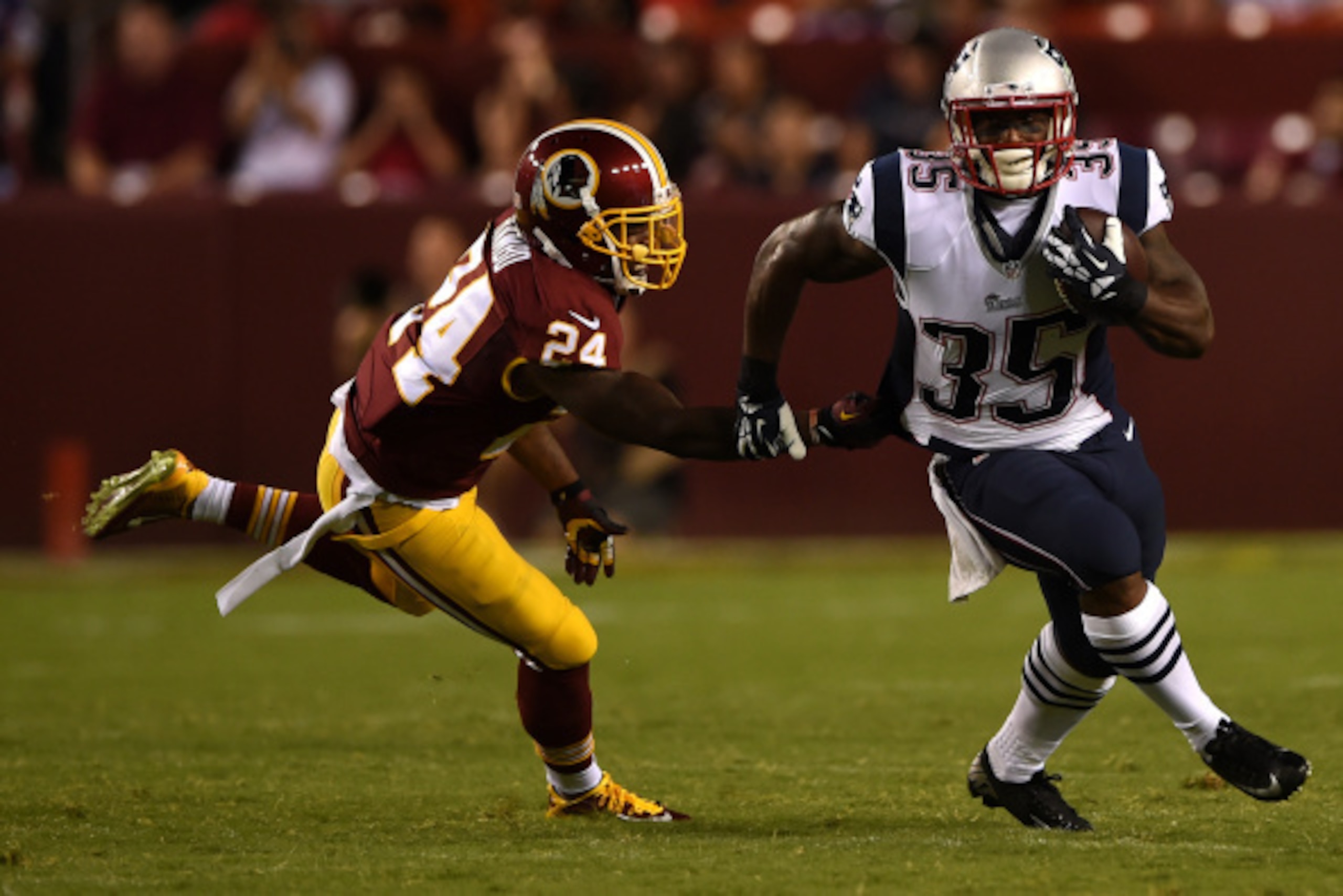 LANDOVER, MD - AUGUST 07: Running back Jonas Gray #35 of the New England Patriots rushes past strong safety Bacarri Rambo #24 of the Washington Redskins during a preseason NFL game at FedExField on August 7, 2014 in Landover, Maryland. The Washington Reds