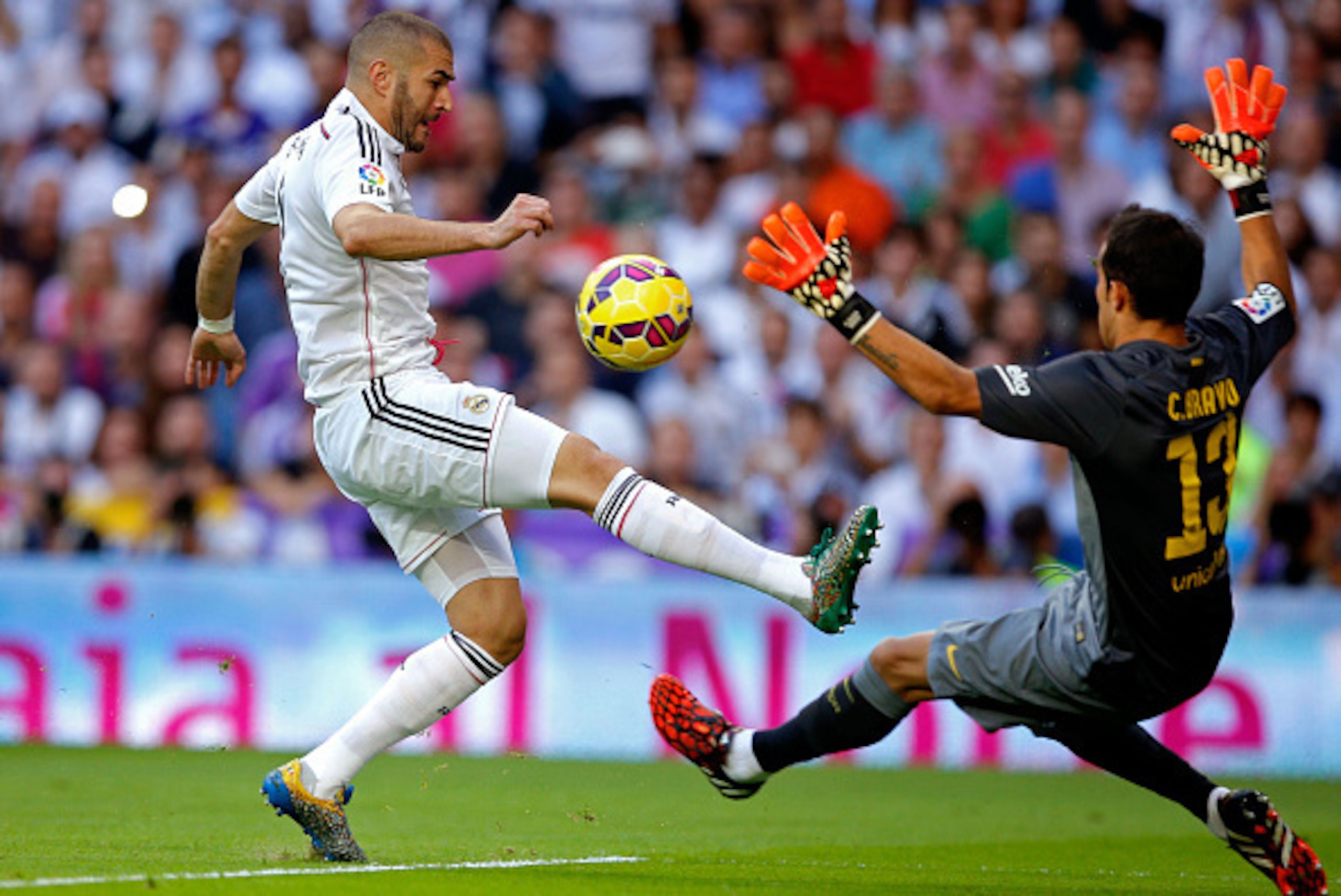 MADRID, SPAIN - OCTOBER 25:  Karim Benzema of Real Madrid CF attempts to lift the ball over Claudio Bravo of FC Barcelona during the La Liga match between Real Madrid CF and FC Barcelona at Estadio Santiago Bernabeu on October 25, 2014 in Madrid, Spain.  