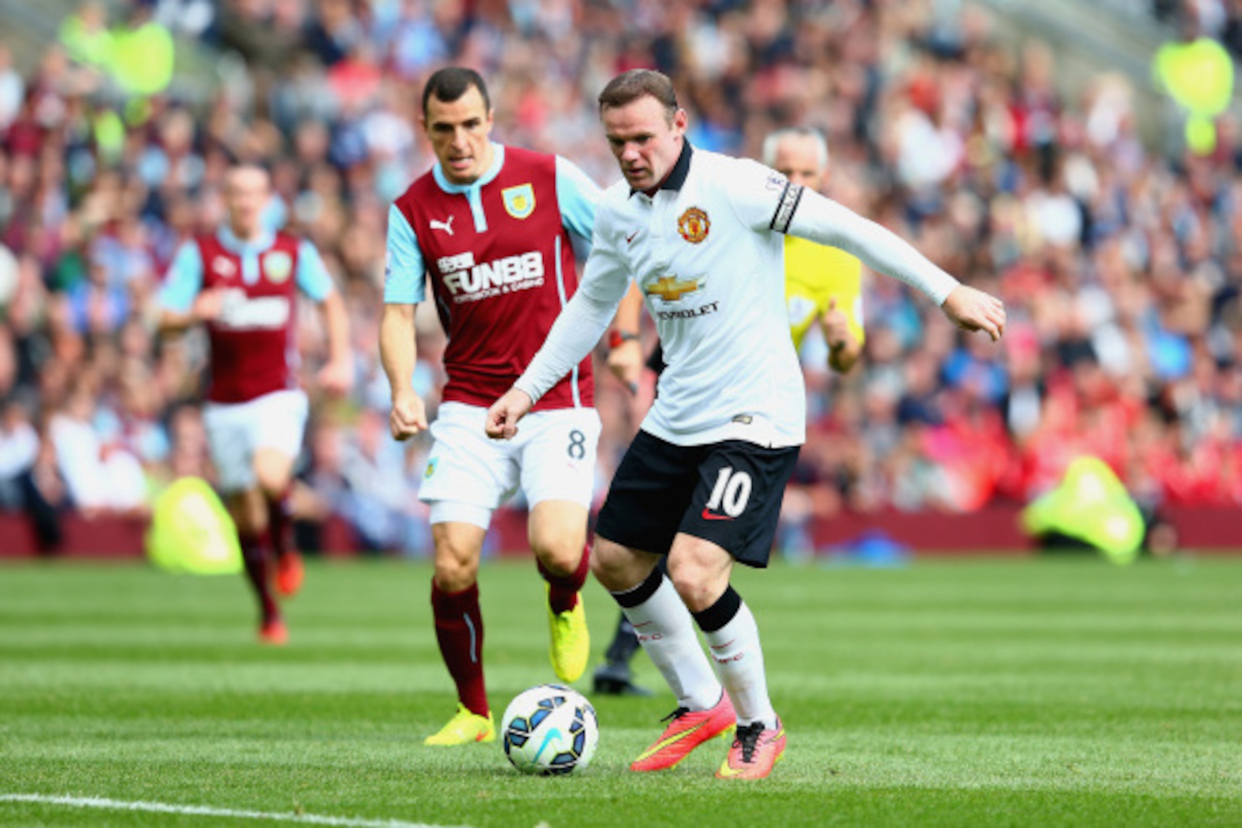 BURNLEY, ENGLAND - AUGUST 30:  Dean Marney of Burnley marshalls Wayne Rooney of Manchester United during the Barclays Premier League match between Burnley and Manchester United at Turf Moor on August 30, 2014 in Burnley, England.  (Photo by Mark Thompson/