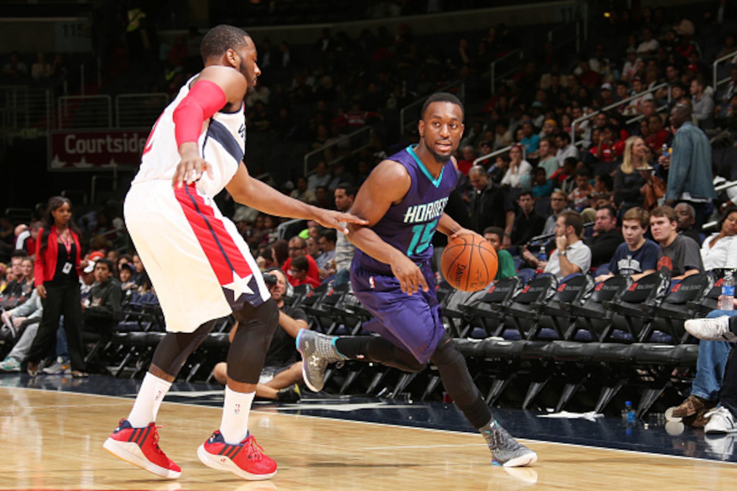 WASHINGTON, DC - OCTOBER 17: Kemba Walker #15 of the Charlotte Hornets drives against John Wall #2 of the Washington Wizards during a preseason game at the Verizon Center on October 17, 2014 in Washington, DC. NOTE TO USER: User expressly acknowledges and