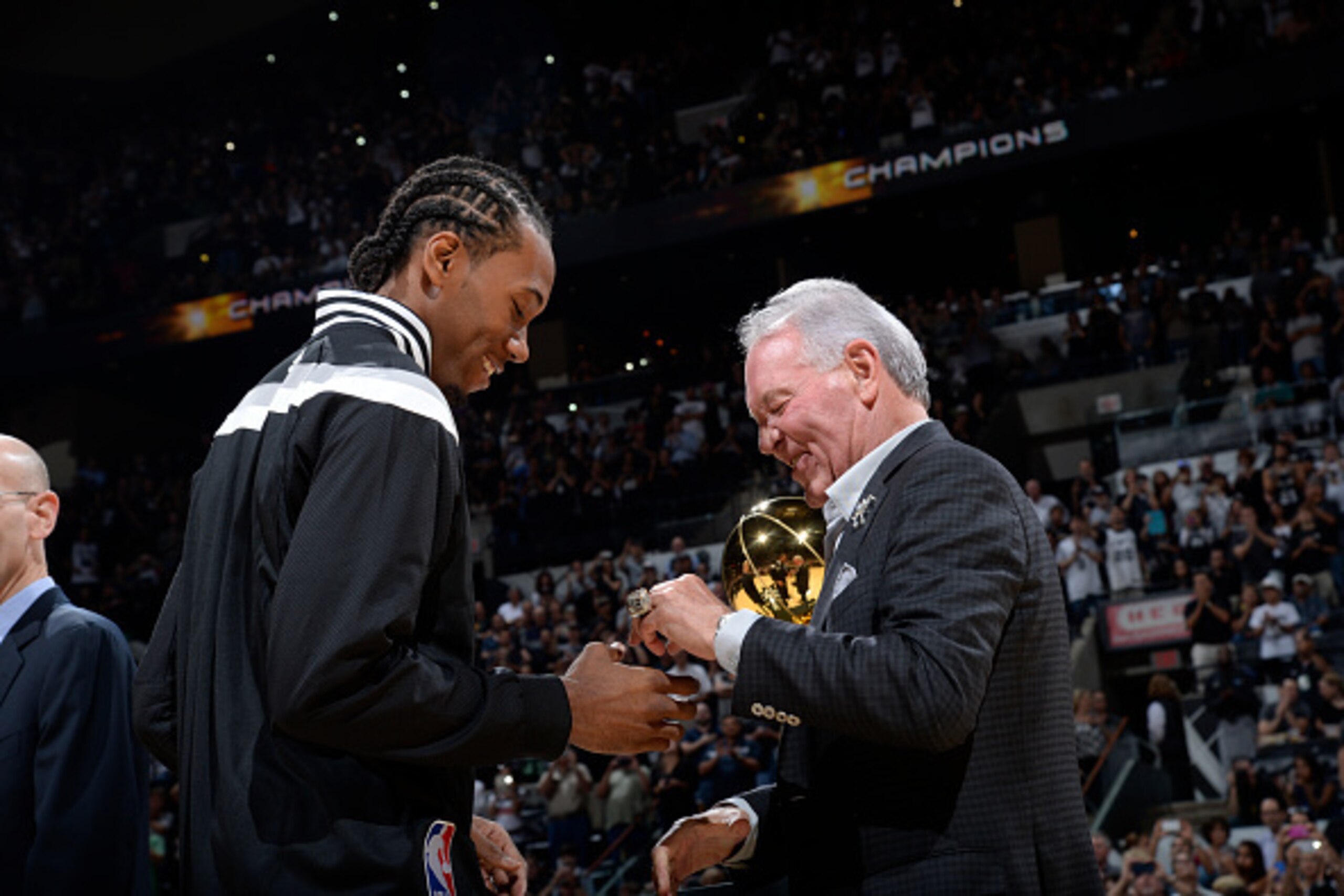 SAN ANTONIO, TX - OCTOBER 28: Kawhi Leonard #2 the San Antonio Spurs receives his Championship Ring from Owner Peter Holt prior to the game against the Dallas Mavericks at the AT&T Center on October 28, 2014 in San Antonio, Texas. NOTE TO USER: User exp SAN ANTONIO, TX - OCTOBER 28: Kawhi Leonard #2 the San Antonio Spurs receives his Championship Ring from Owner Peter Holt prior to the game against the Dallas Mavericks at the AT&T Center on October 28, 2014 in San Antonio, Texas. NOTE TO USER: User exp