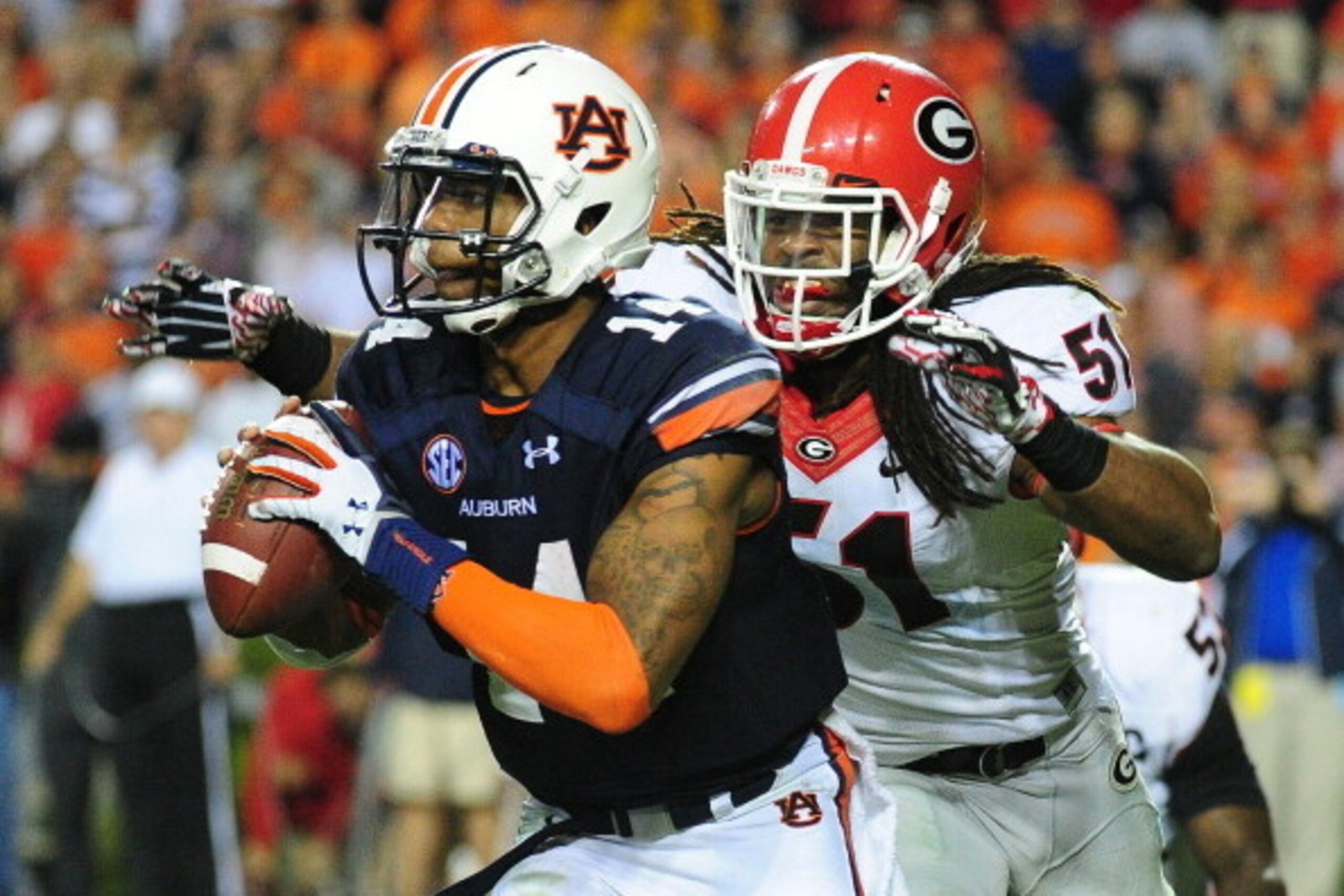 AUBURN, AL - NOVEMBER 16: Nick Marshall #14 of the Auburn Tigers is pursued by Ramik Wilson #51 of the Georgia Bulldogs at Jordan-Hare Stadium on November 16, 2013 in Auburn Alabama. (Photo by Scott Cunningham/Getty Images)