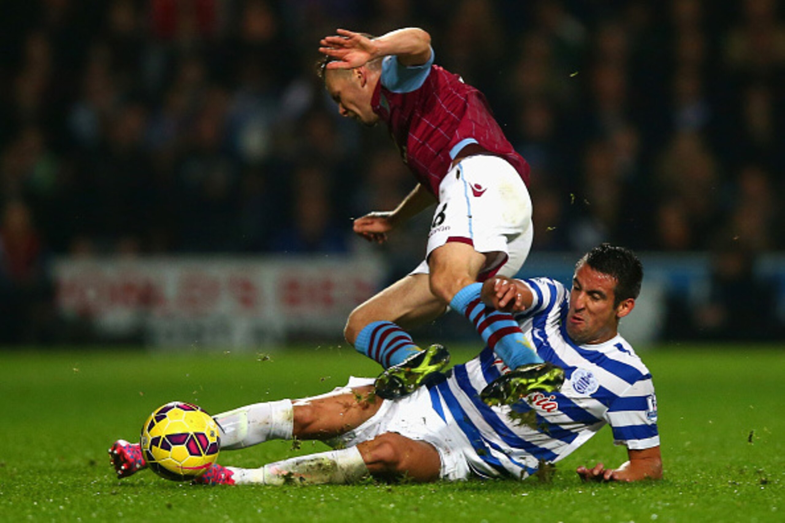 LONDON, ENGLAND - OCTOBER 27:  Mauricio Isla of QPR slides in to tackle Tom Cleverley of Aston Villa during the Barclays Premier League match between Queens Park Rangers and Aston Villa at Loftus Road on October 27, 2014 in London, England.  (Photo by Cli