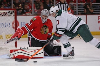 CHICAGO, IL - MAY 11: Zach Parise #11 of the Minnesota Wild tries to get off a shot against Corey Crawford #50 of the Chicago Blackhawks in Game Five of the Second Round of the 2014 NHL Stanley Cup Playoffs at the United Center on May 11, 2014  in Chicago