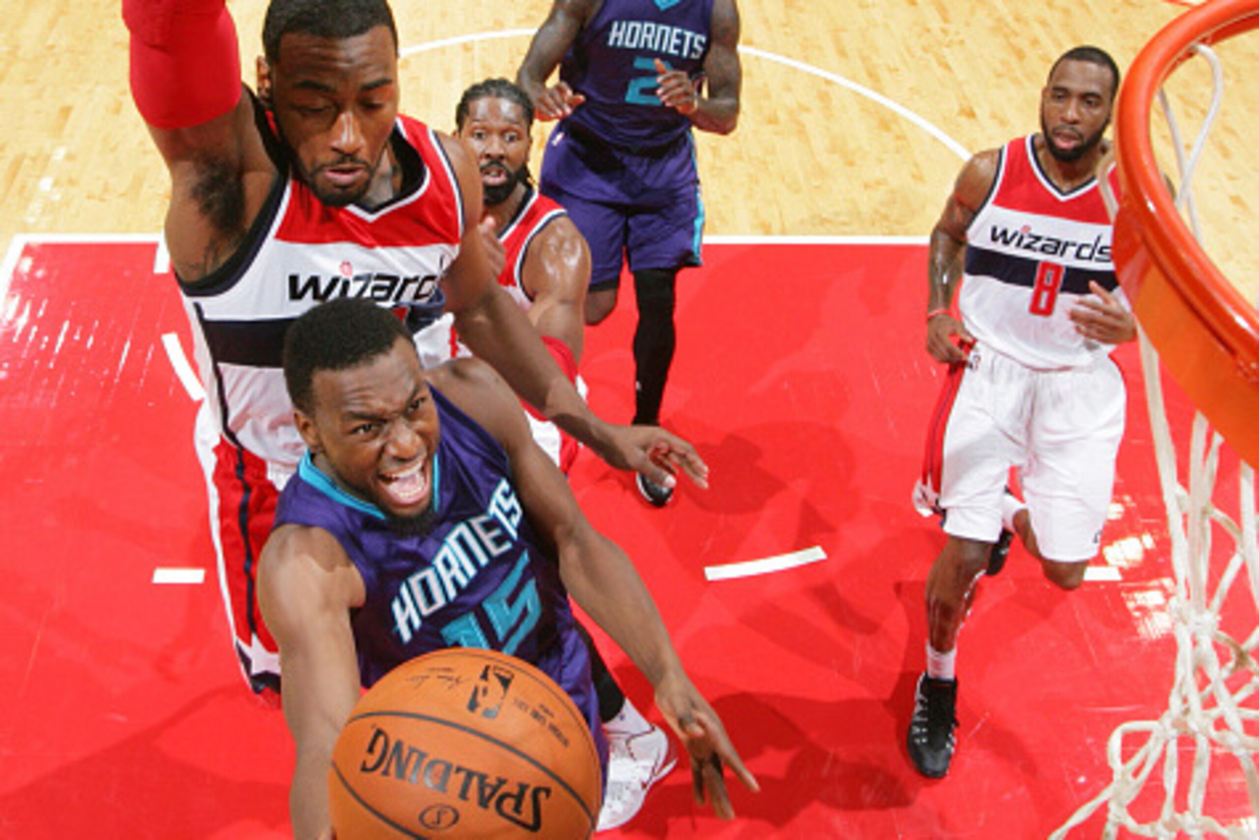 WASHINGTON, DC - OCTOBER 17: Kemba Walker #15 of the Charlotte Hornets shoots against John Wall #2 of the Washington Wizards during a preseason game at the Verizon Center on October 17, 2014 in Washington, DC. NOTE TO USER: User expressly acknowledges and