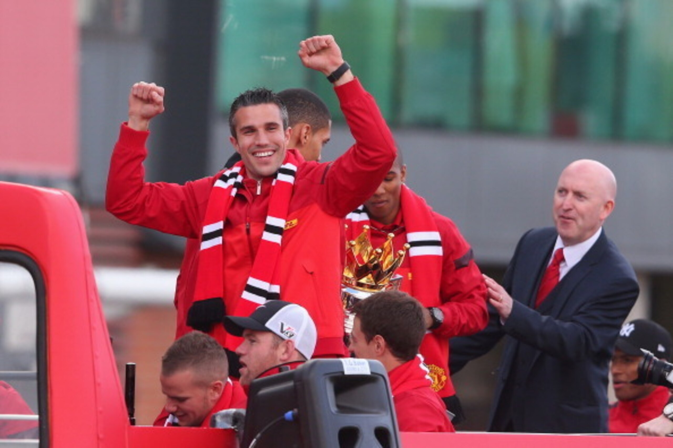 MANCHESTER, ENGLAND - MAY 13:  Robin Van Persie celebrates onboard the open topped bus outside Old Trafford as Wayne Rooney looks on during the Manchester United Premier League winners parade on May 13, 2013 in Manchester, England.  (Photo by Alex Livesey