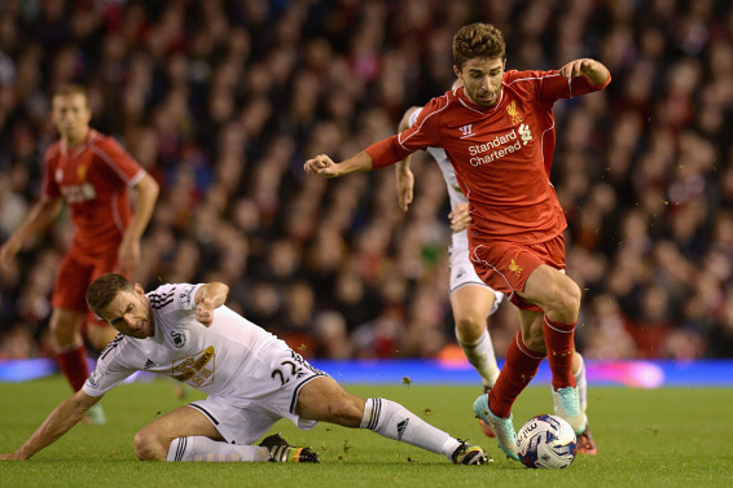 LIVERPOOL, ENGLAND - OCTOBER 28:  Fabio Borini of Liverpool is tackled by Angel Rangel of Swansea during the Capital One Cup Fourth Round match between Liverpool and Swansea City at Anfield on October 28, 2014 in Liverpool, England.  (Photo by Gareth Copl