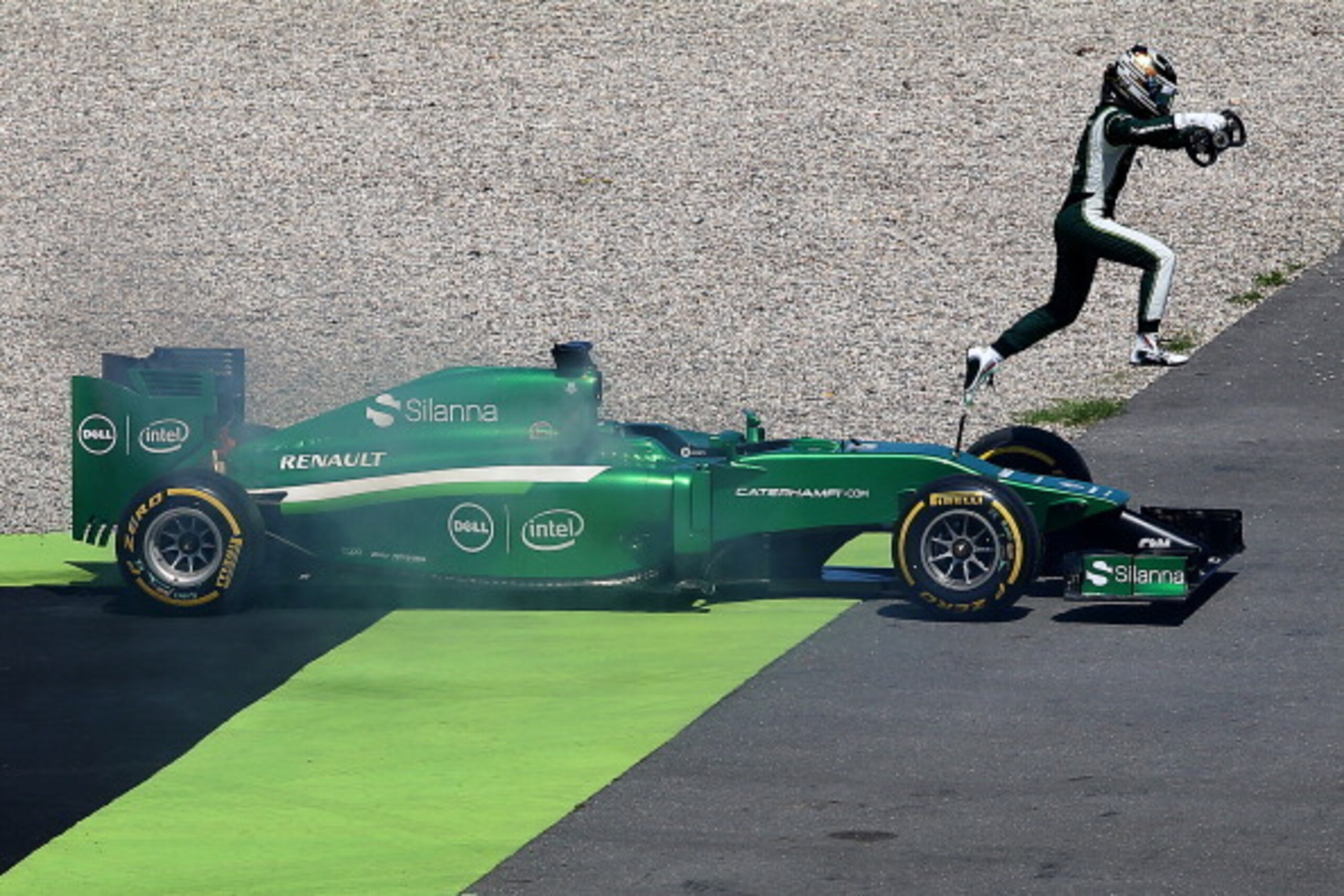HOCKENHEIM, GERMANY - JULY 18:  Kamui Kobayashi of Japan and Caterham jumps from his car as smoke rises from the vehicle during practice ahead of the German Grand Prix at Hockenheimring on July 18, 2014 in Hockenheim, Germany.  (Photo by Mark Thompson/Get