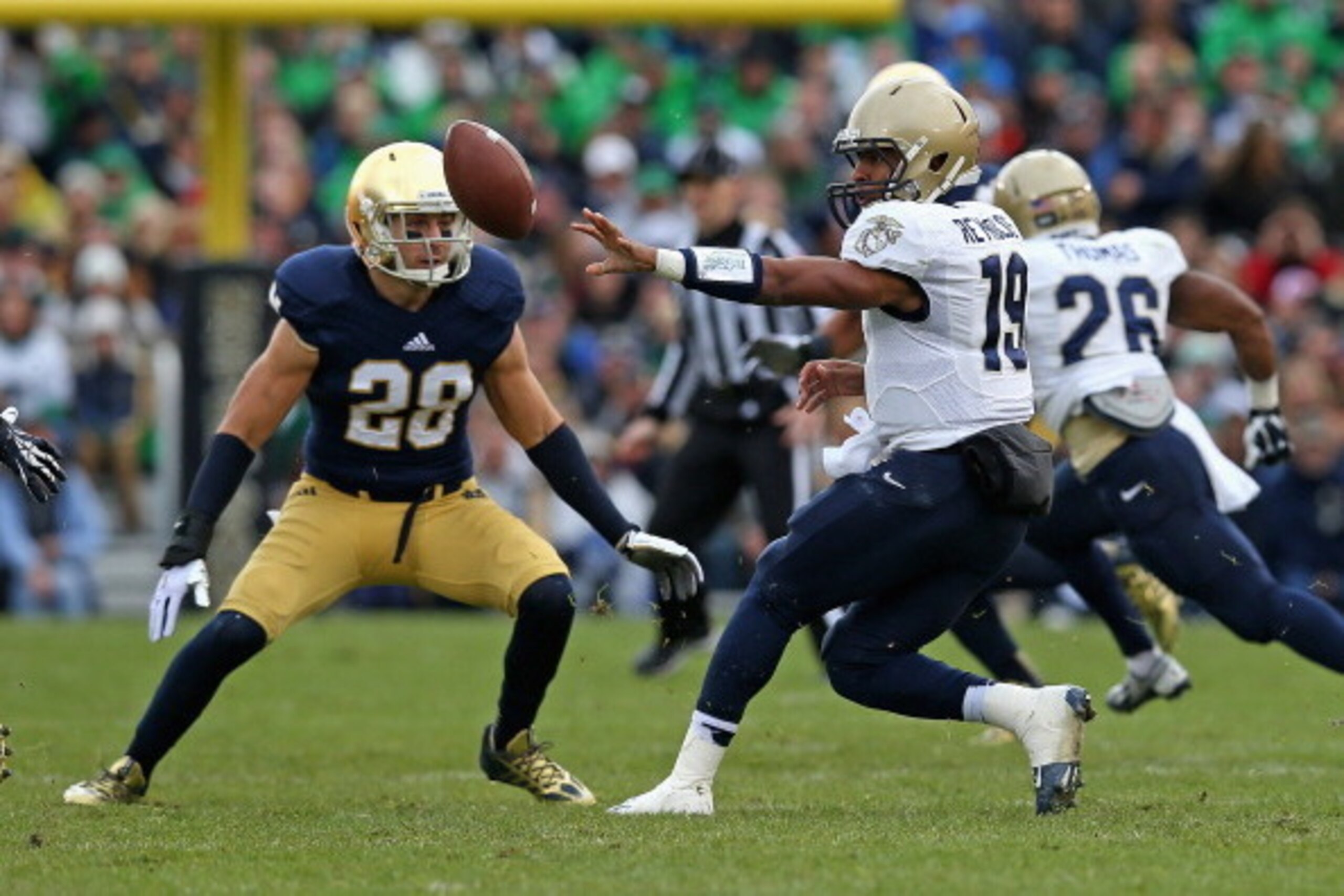 SOUTH BEND, IN - NOVEMBER 02: Keenan Reynolds #19 of the Navy Midshipmen pitches the ball in front of Austin Collinsworth #28 of the Notre Dame Fighting Irish at Notre Dame Stadium on November 2, 2013 in South Bend, Indiana. Notre Dame defeated Navy 38-34