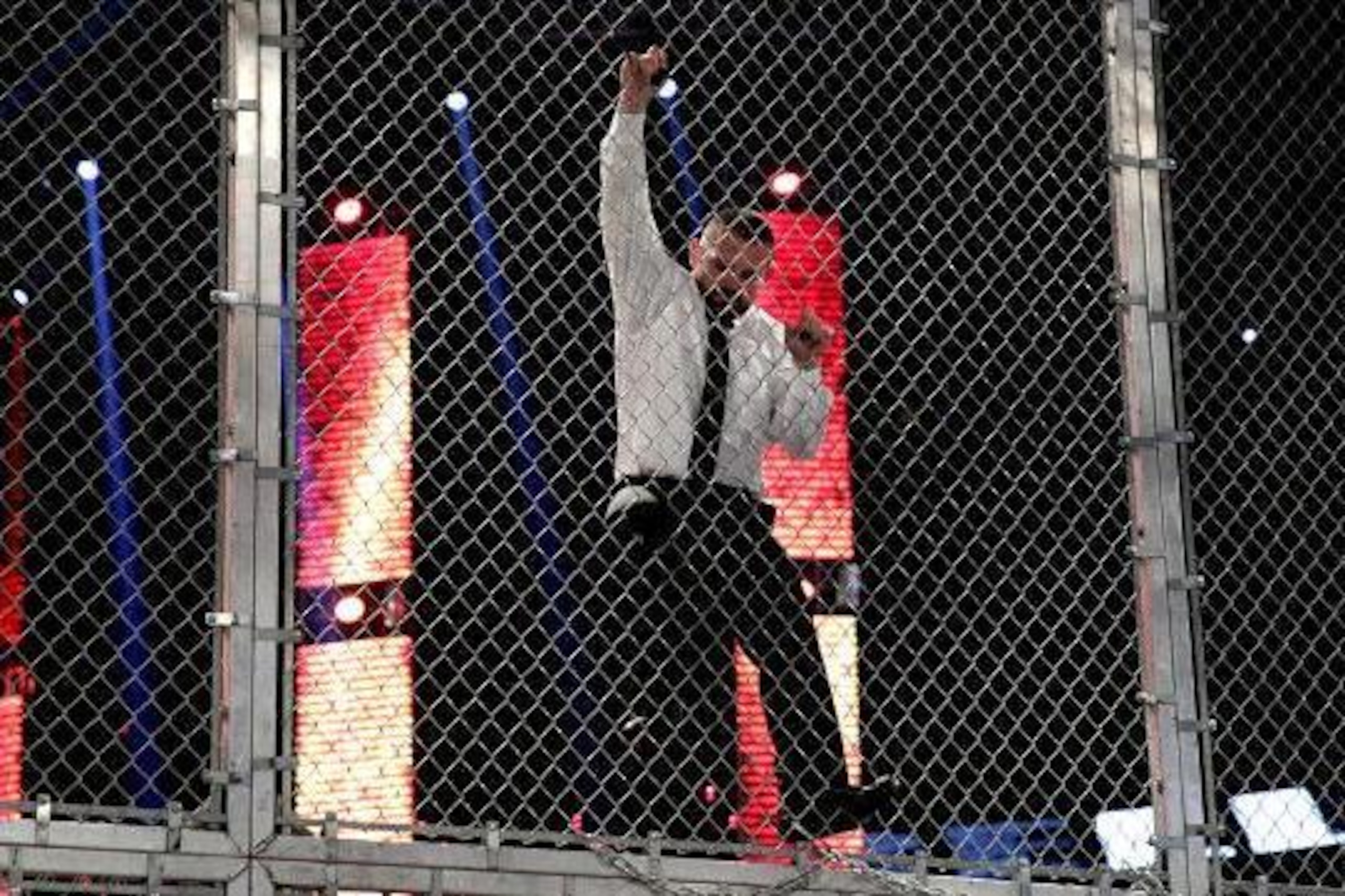 Jamie Noble climbs the cell.