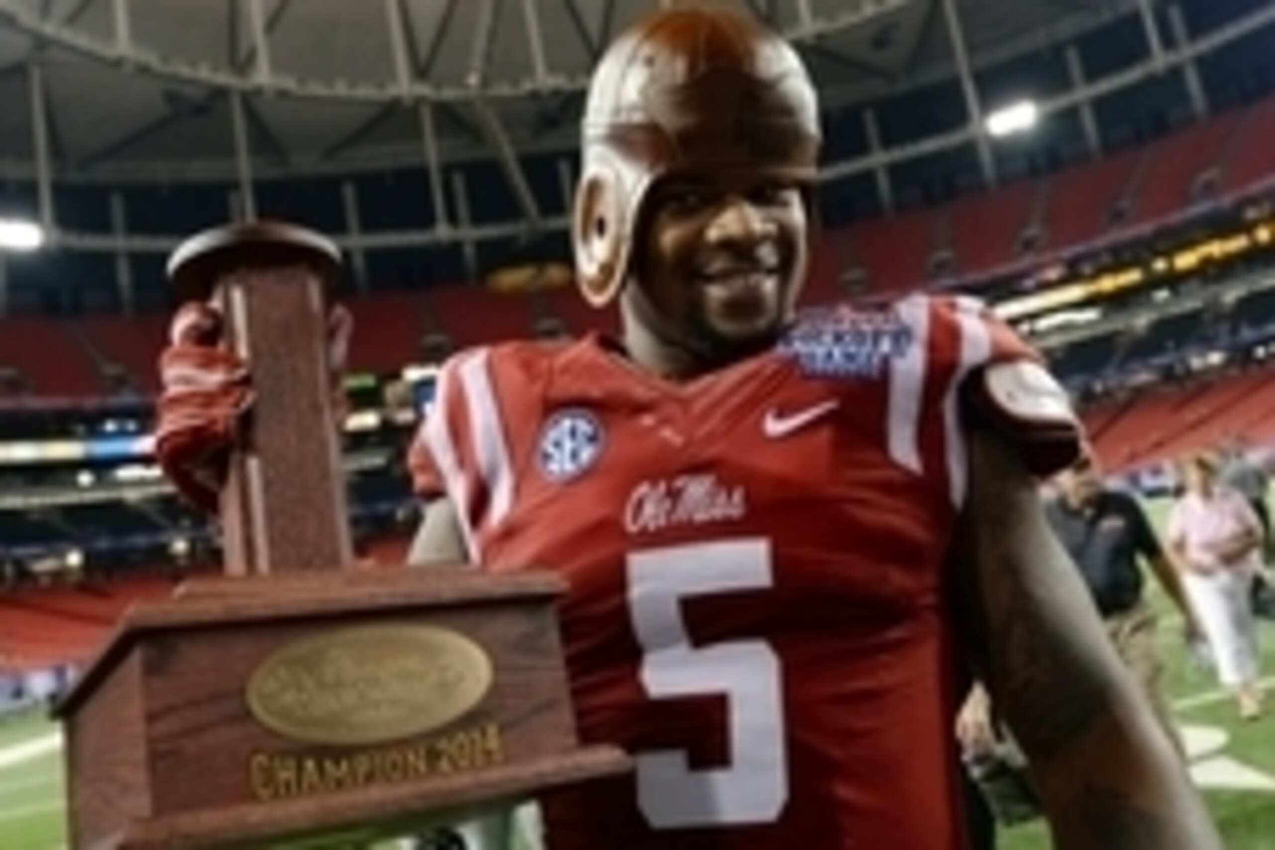 Aug 28, 2014; Atlanta, GA, USA; Mississippi Rebels defensive tackle Robert Nkemdiche (5) celebrates with the old leather helmet after defeating the Boise State Broncos in the 2014 Chick-fil-A kickoff game at the Georgia Dome. Rebels won 35-13. Mandatory C
