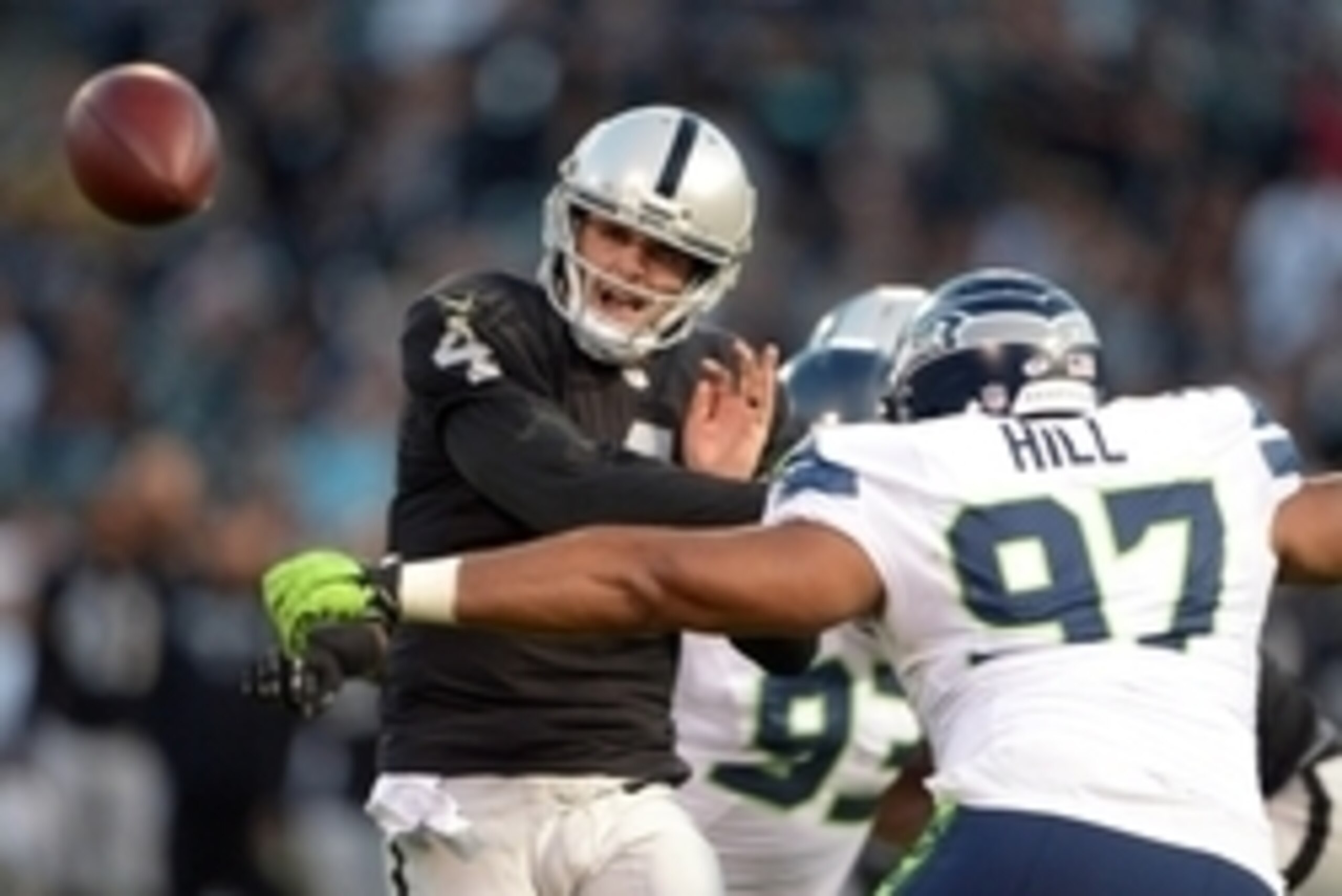 Aug 28, 2014; Oakland, CA, USA; Oakland Raiders quarterback Derek Carr (4) throws a pass under pressure from Seattle Seahawks defensive tackle Jordan Hill (97) at O.co Coliseum. Mandatory Credit: Kirby Lee-USA TODAY Sports