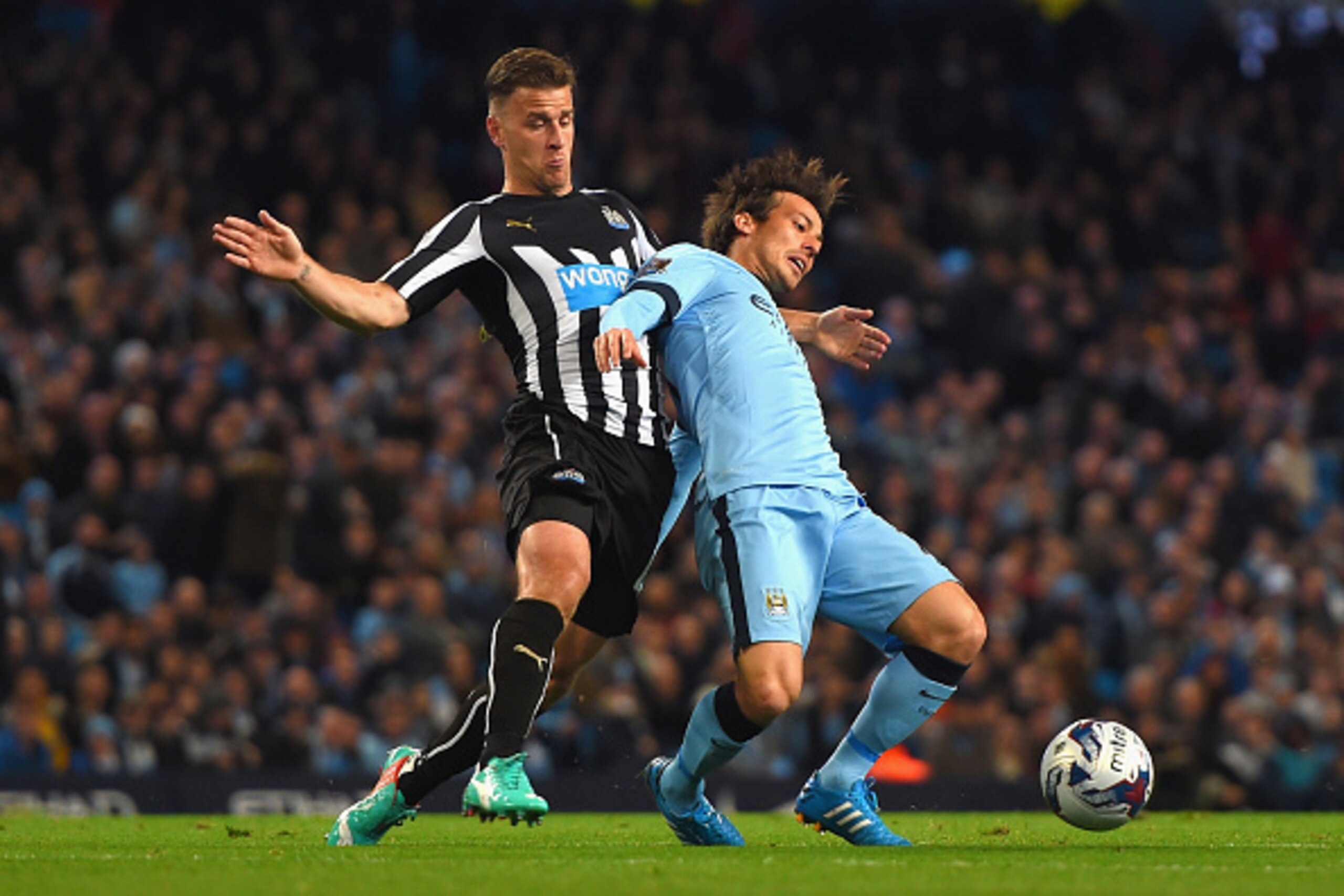 MANCHESTER, ENGLAND - OCTOBER 29: David Silva of Manchester City is tackled by Ryan Taylor of Newcastle United  during the Capital One Cup Fourth Round match between Manchester City and Newcastle United at Etihad Stadium on October 29, 2014 in Manchester,