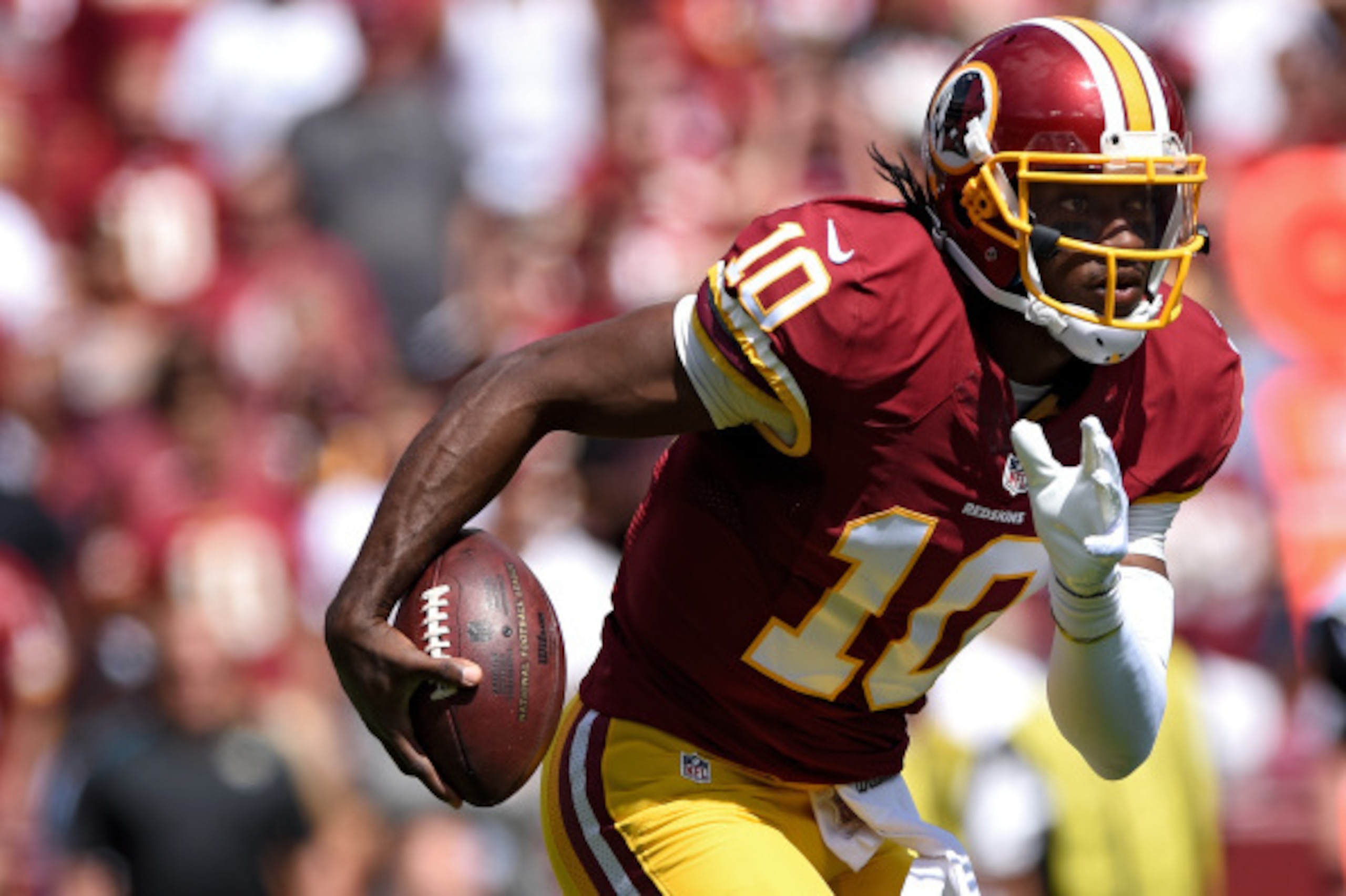 LANDOVER, MD - SEPTEMBER 14: Quarterback Robert Griffin III #10 of the Washington Redskins rushes against the Jacksonville Jaguars in the first half at FedExField on September 14, 2014 in Landover, Maryland. The Washington Redskins won, 41-10. (Photo by P