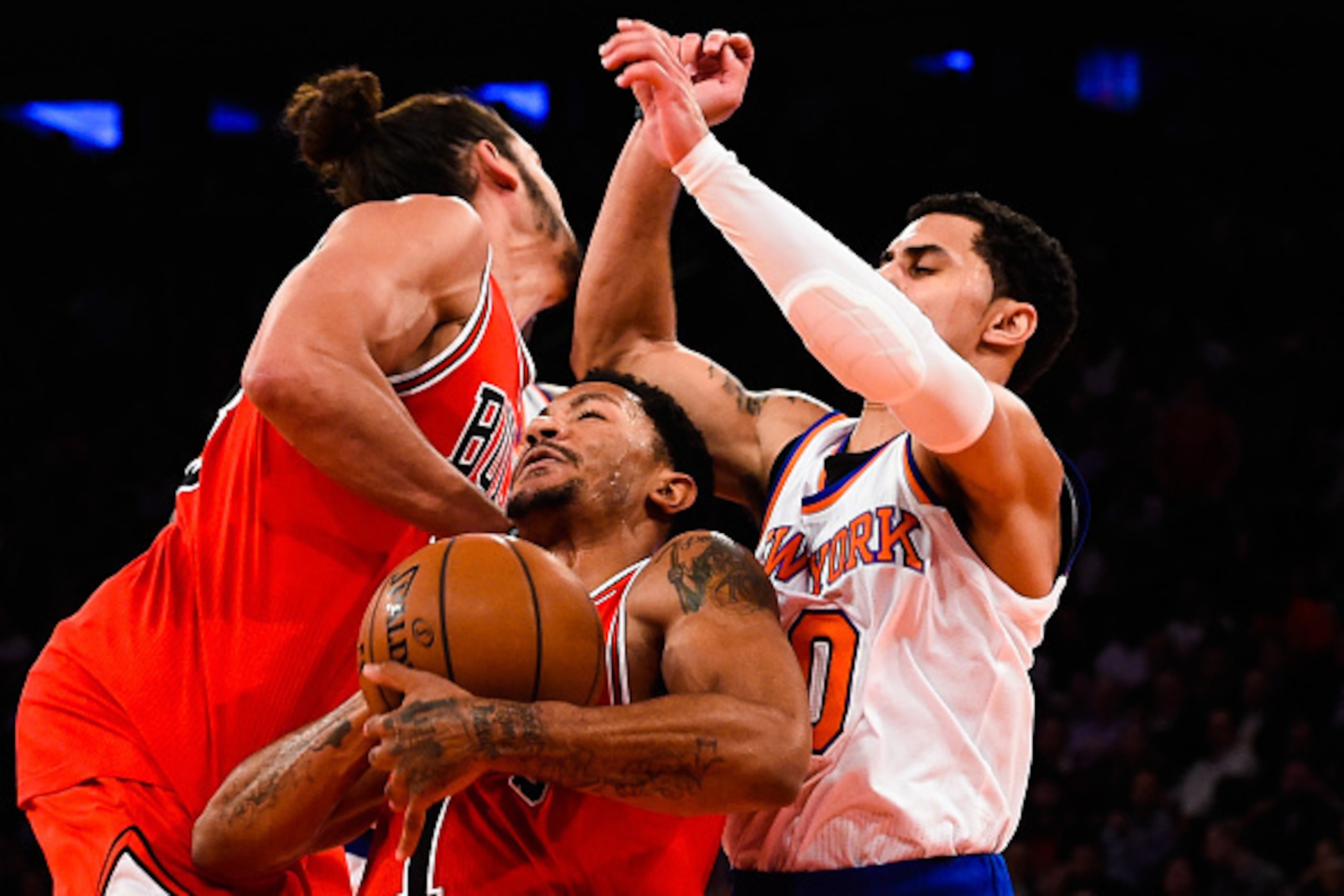 NEW YORK, NY - OCTOBER 29: Derrick Rose #1 of the Chicago Bulls is fouled while attempting to dribble between teammate Joakim Noah #13 and Shane Larkin #0 of the New York Knicks in the second quarter during a game at Madison Square Garden on October 29, 2