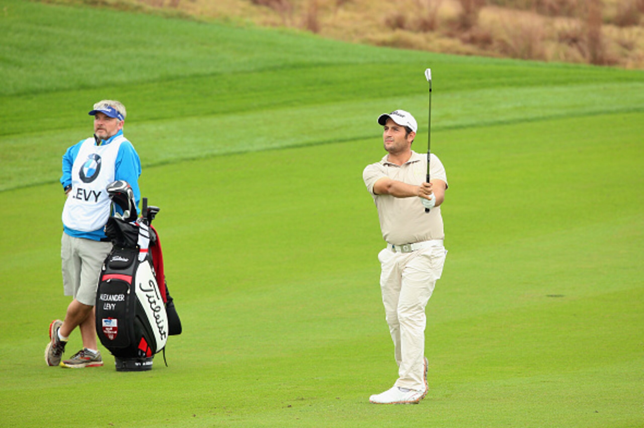 SHANGHAI, CHINA - OCTOBER 30:  Alexander Levy of France plays his second shot on the tenth hole as his caddie Alexander Levy; Brian Bo Martin looks on during the first round of the BMW Masters at Lake Malaren Golf Club on October 30, 2014 in Shanghai, Chi