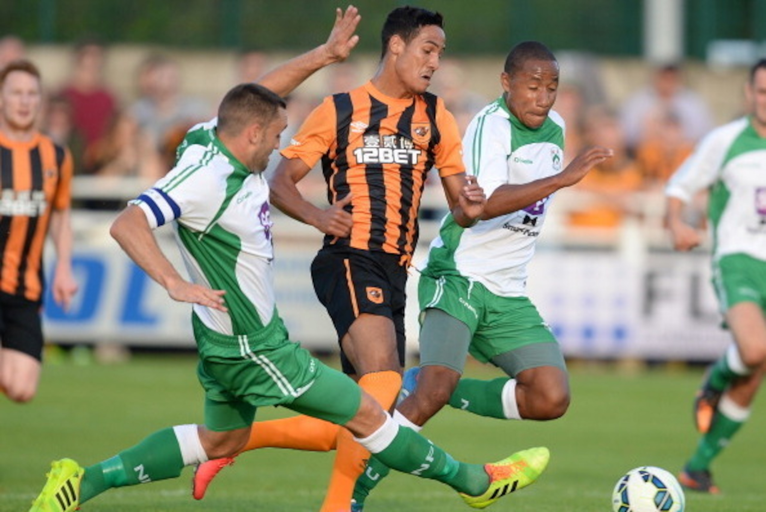 NORTH FERRIBY, ENGLAND - JULY 21: Tom Ince (C) of  Hull City is challenged by Russell Fry (L) and Jon D'Laryea of North Ferriby United during a pre-season friendly match between North Ferriby United and Hull City at the eon visual media stadium on July 21