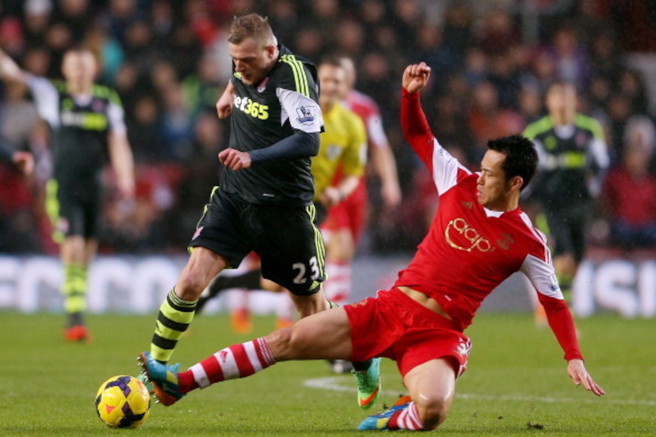 SOUTHAMPTON, ENGLAND - FEBRUARY 08:  Maya Yoshida of Southampton (R) slides in on John Guidetti  of Stoke during the Barclays Premier League match between Southampton and Stoke City at St Mary's Stadium on February 8, 2014 in Southampton, England.  (Photo