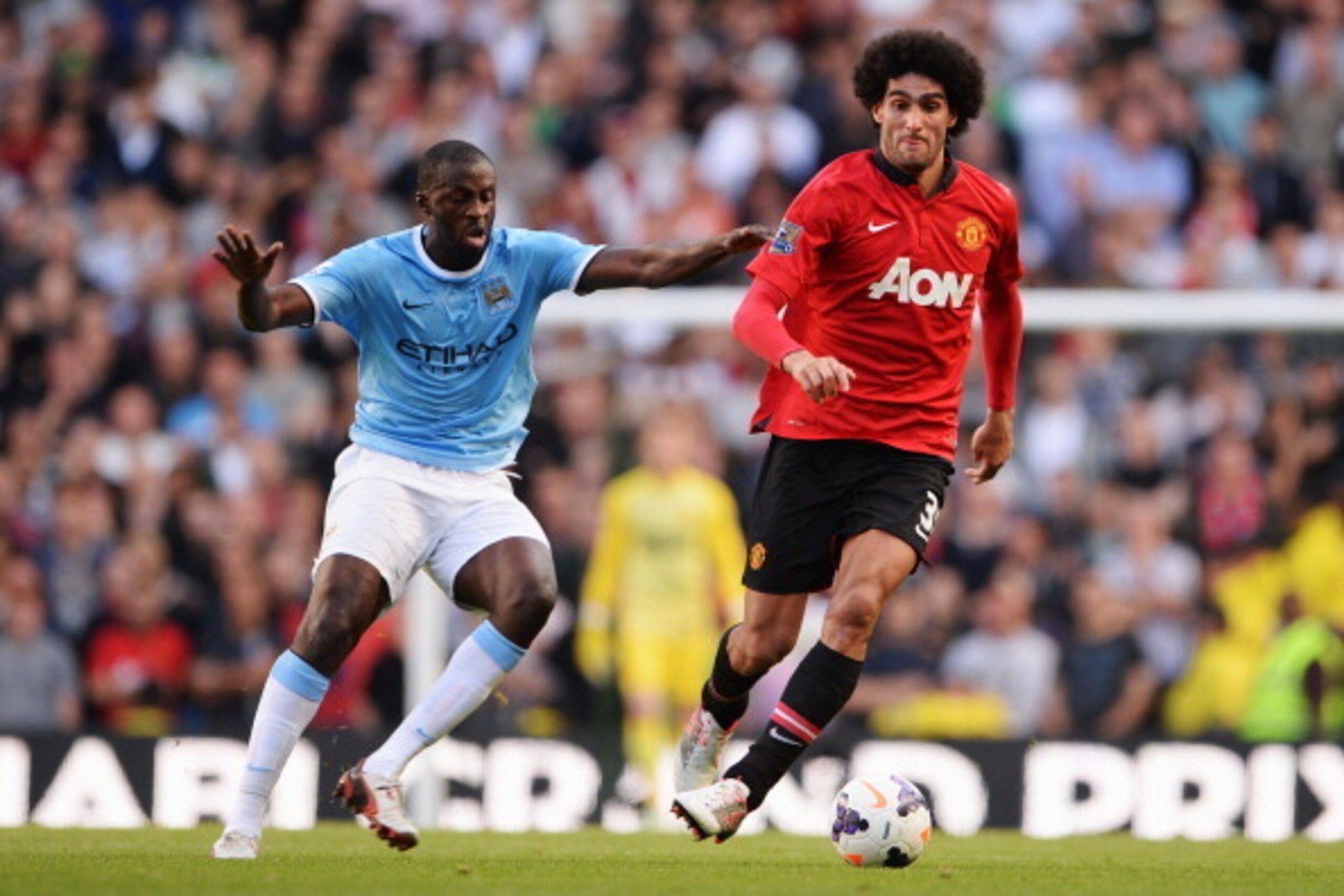 MANCHESTER, ENGLAND - SEPTEMBER 22: Marouane Fellaini of Manchester United evades Yaya Toure of Manchester City during the Barclays Premier League match between Manchester City and Manchester United at the Etihad Stadium on September 22, 2013 in Manchest MANCHESTER, ENGLAND - SEPTEMBER 22: Marouane Fellaini of Manchester United evades Yaya Toure of Manchester City during the Barclays Premier League match between Manchester City and Manchester United at the Etihad Stadium on September 22, 2013 in Manchest